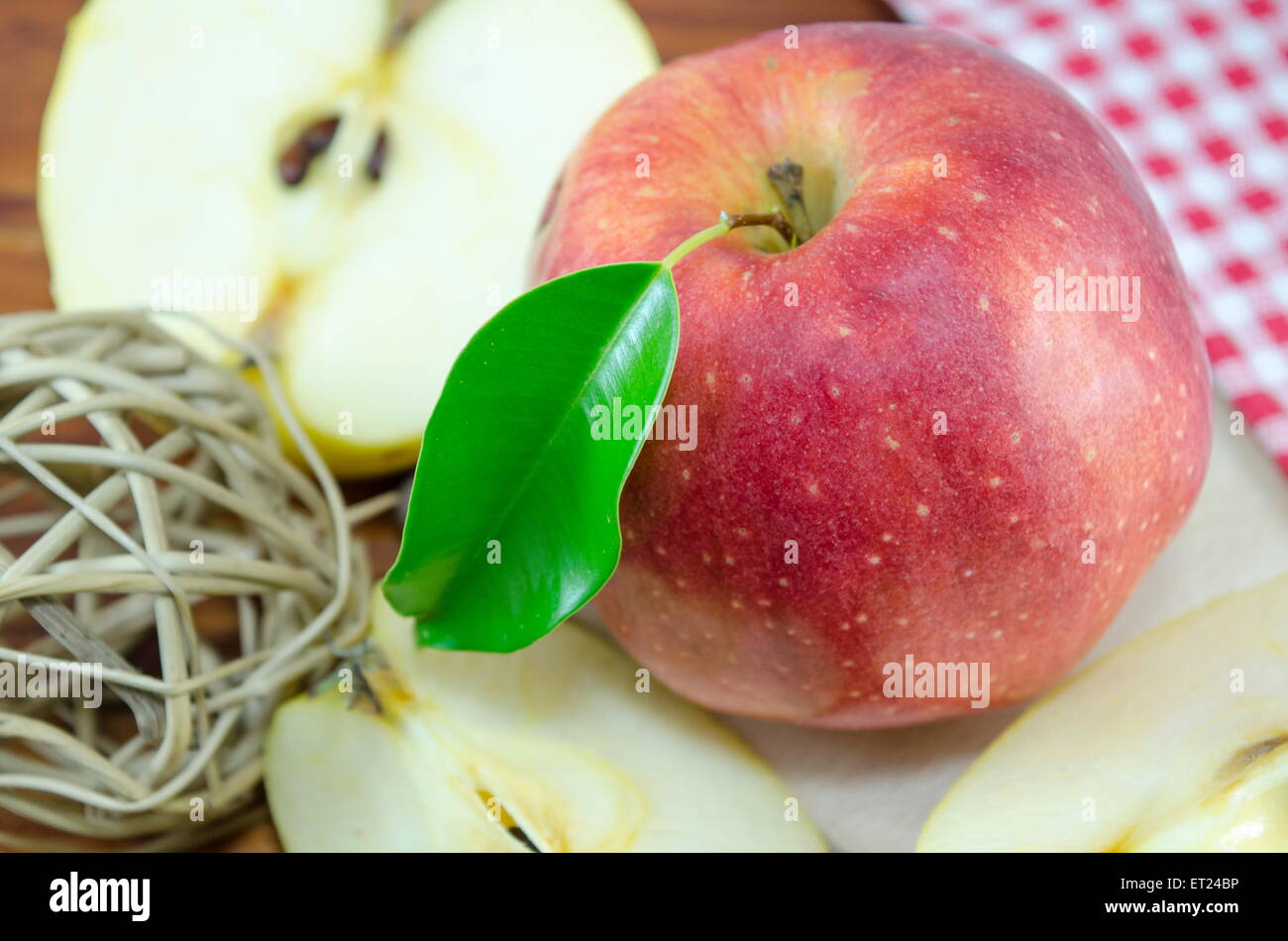 Halved and whole red apple on a table with a handmade decoration Stock Photo
