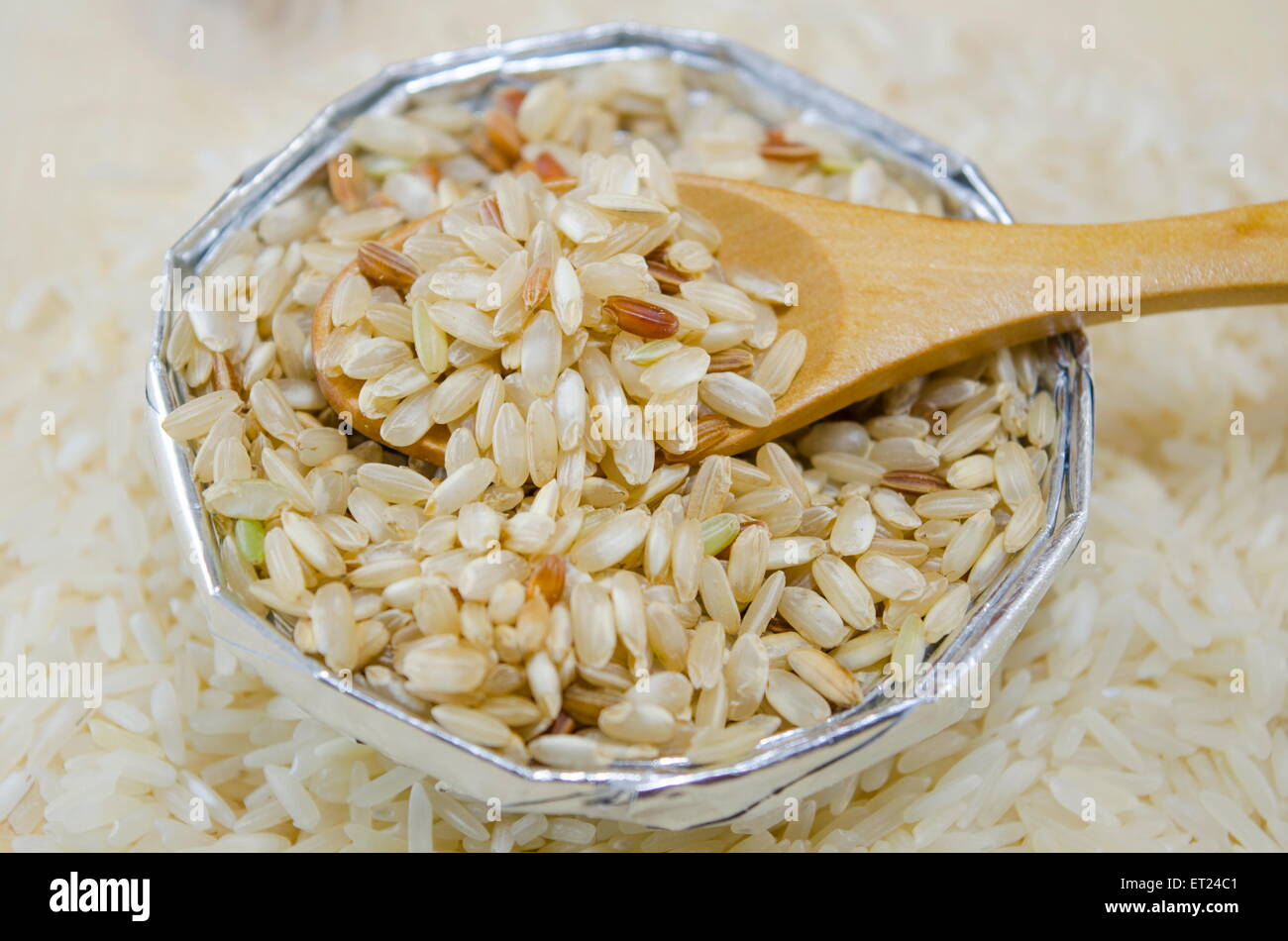 Rice in an aluminum bowl on a table covered with rice Stock Photo