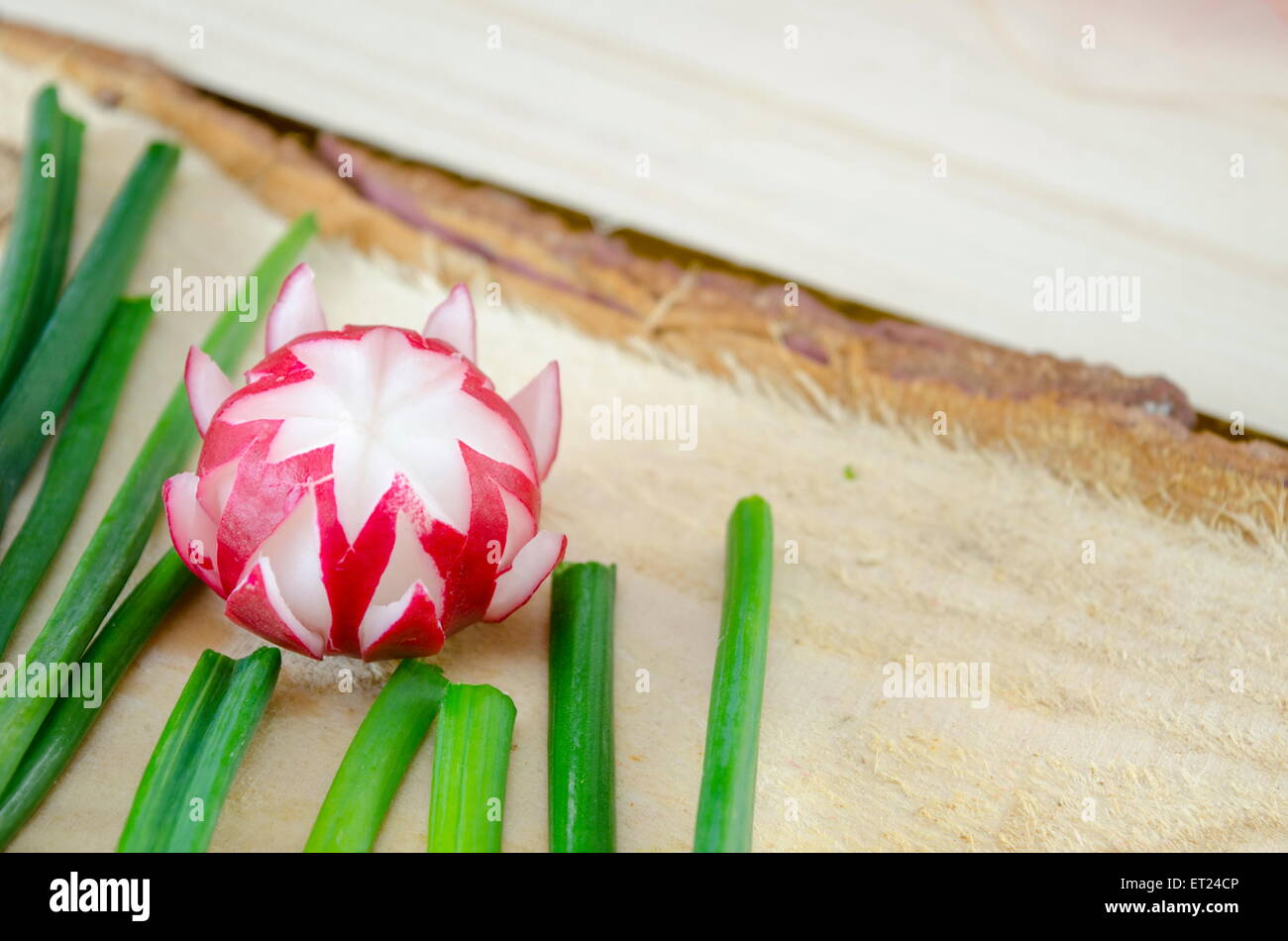 Decorated red radish on a rough wooden surface Stock Photo