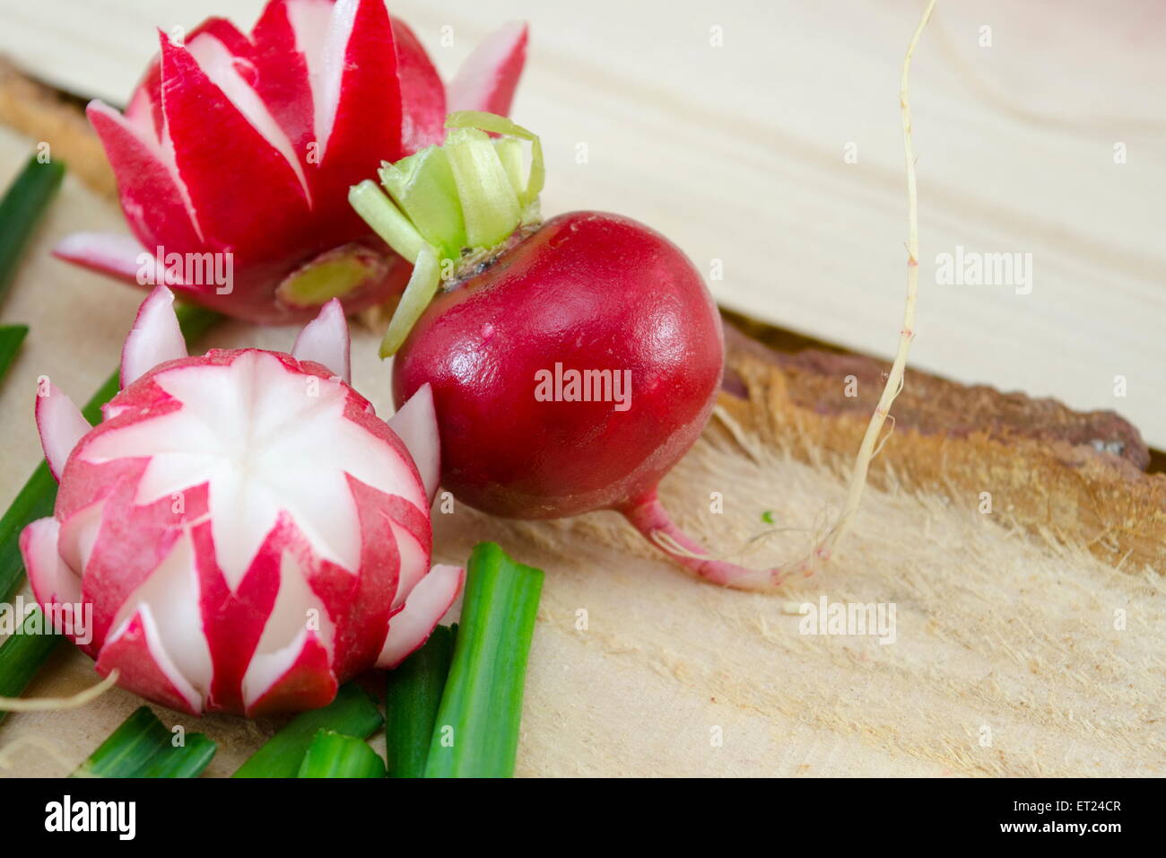 Decorated red radish on a rough wooden surface Stock Photo - Alamy