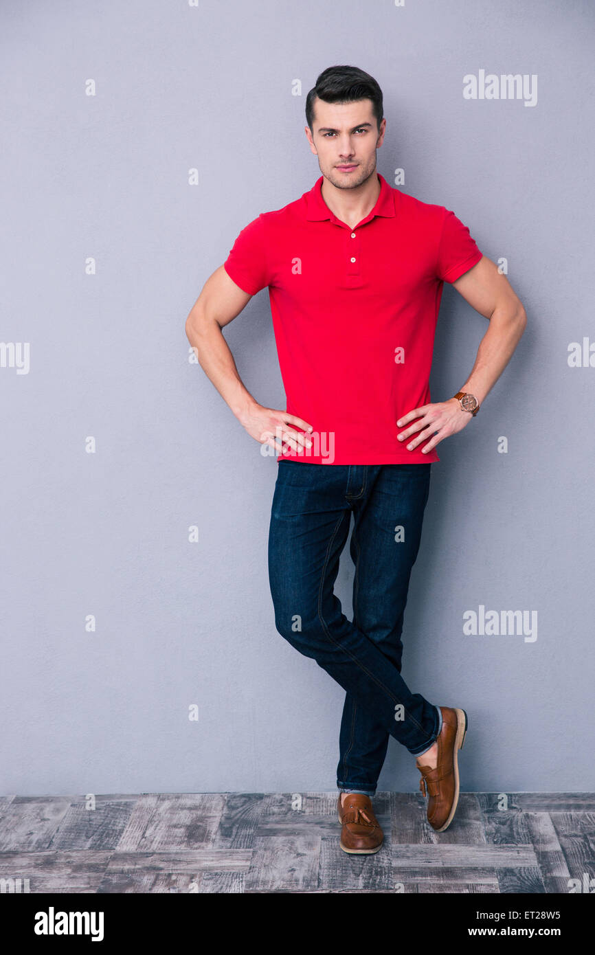 Full length portrait of a handsome man standing over gray background ...