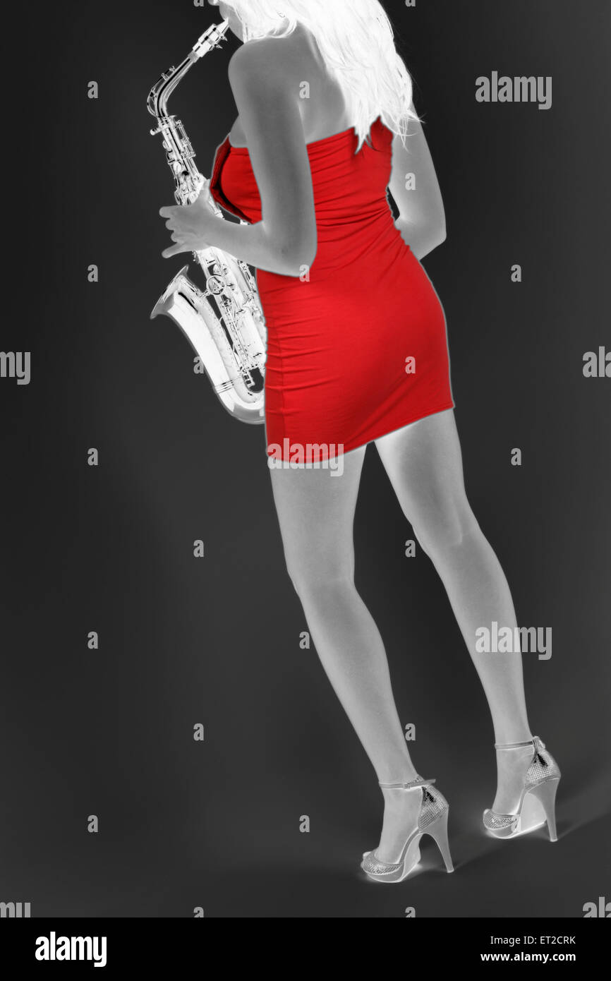 Alto Sax player. Coloured woman in a tight red dress. Jazz, pop, funk, rock, Stock Photo