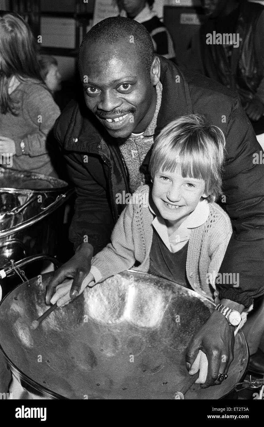 North Star steel drummer Kelvin Benjamin helps Sarah Stead play the soprano drum during the Kirklees multicultural festival. 2nd March 1988. Stock Photo