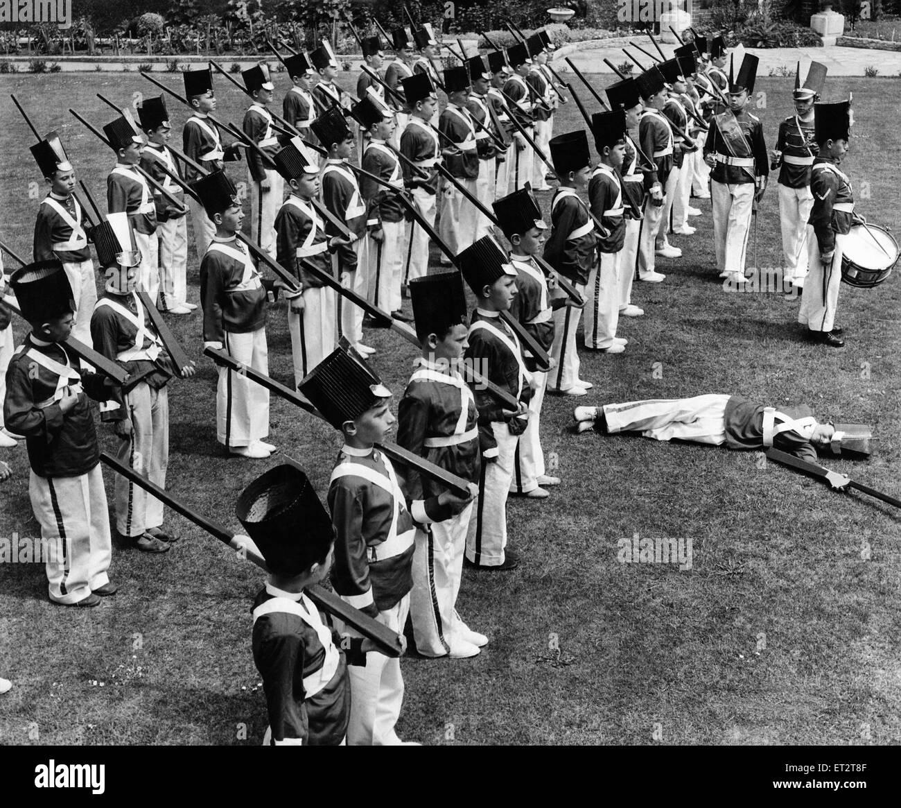 Children's Games: The Guardsman that fainted on parade. 60 small boys dressed as Grenadier Guardsmen were busy square-bashing on a beautiful lawn of St. Joseph's Academy Leigh Terrace Black Heath London today in preparation for their Sports Day which take Stock Photo