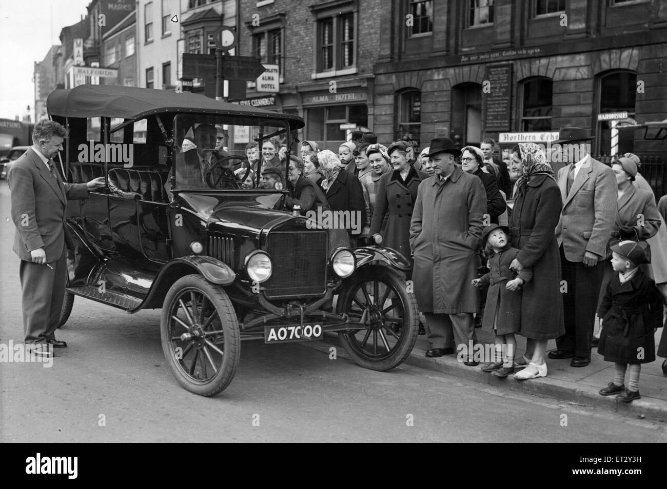 An interested crowd gathers round this T Model Ford car as it pulls up in Stockton High Street, before going to the the Oxbridge Garage, 20th May 1955. Stock Photo