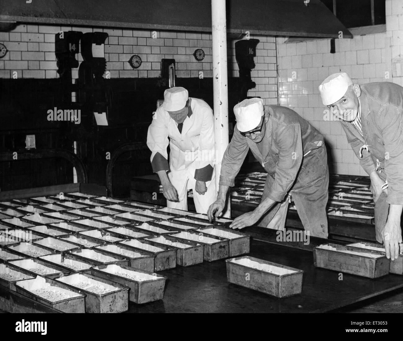 Export 'Dundee' cakes are loaded onto the oven trays in the Avana Bakery, Cardiff. Mr J March, ovens manager (left) with Mr E Watts and Mr F Whitmore, ovensmen. January 1965. Stock Photo