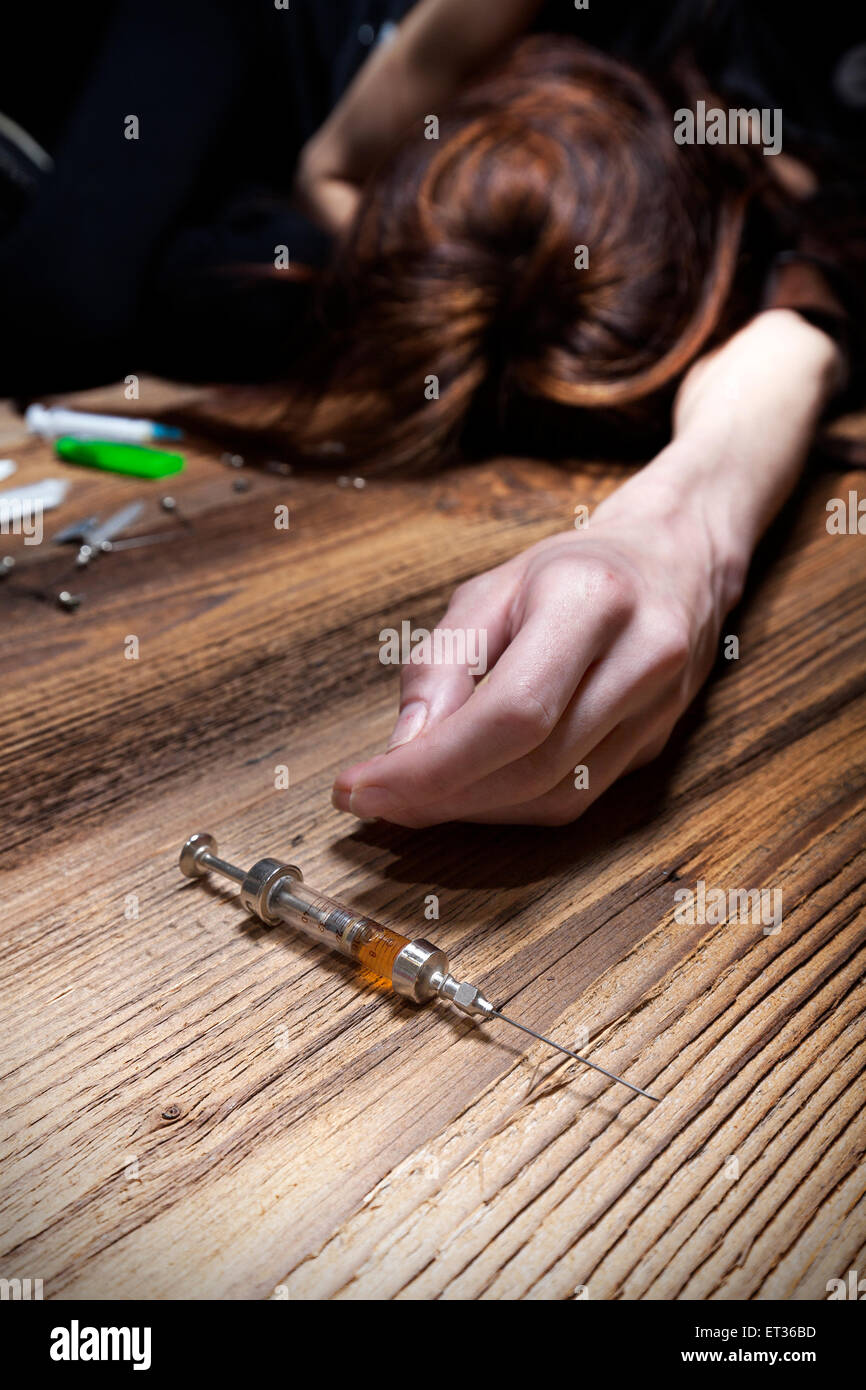 Young woman poses as an unconscious drug addict, concept photo. Stock Photo
