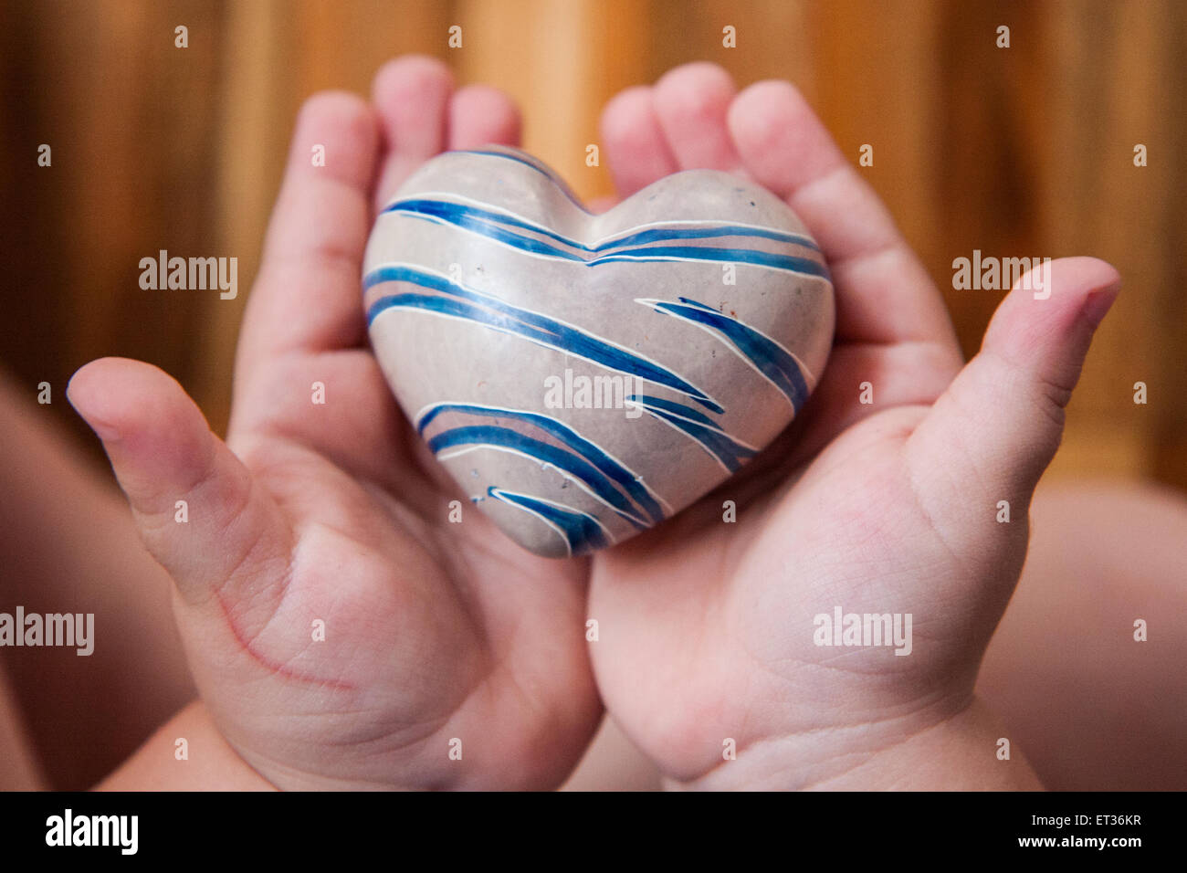 Child Hands Holding A Heart Of Stone Stock Photo Alamy