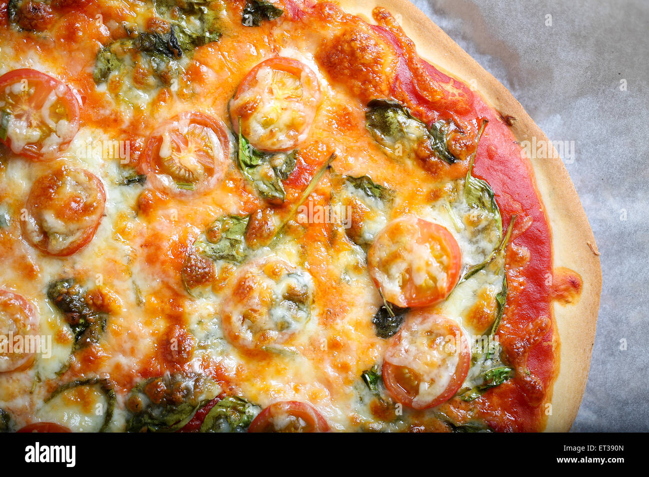 Traditional home made thin crust pizza with spinach, tomato, and ...