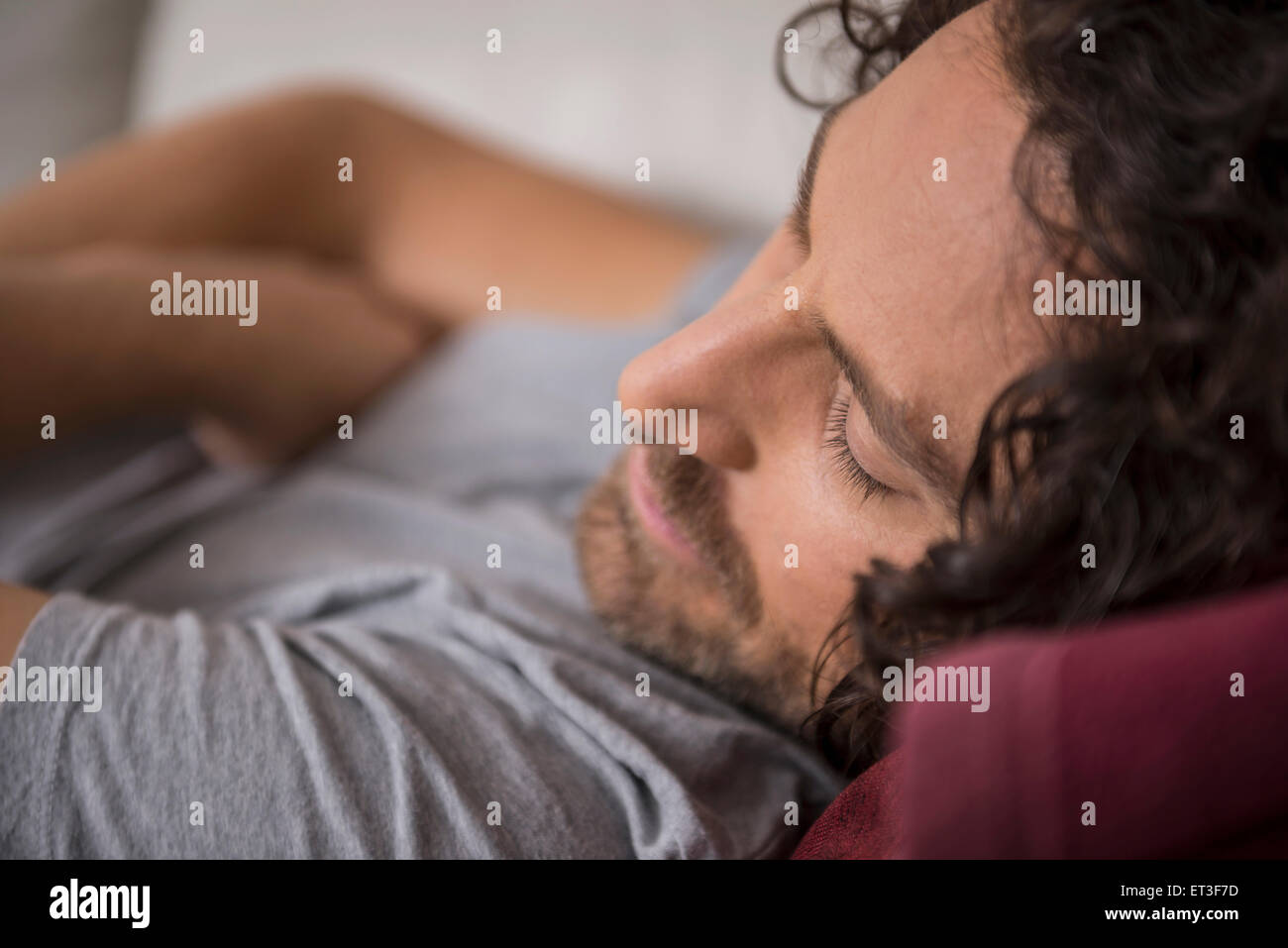 Mid adult man sleeping on couch, Munich, Bavaria, Germany Stock Photo