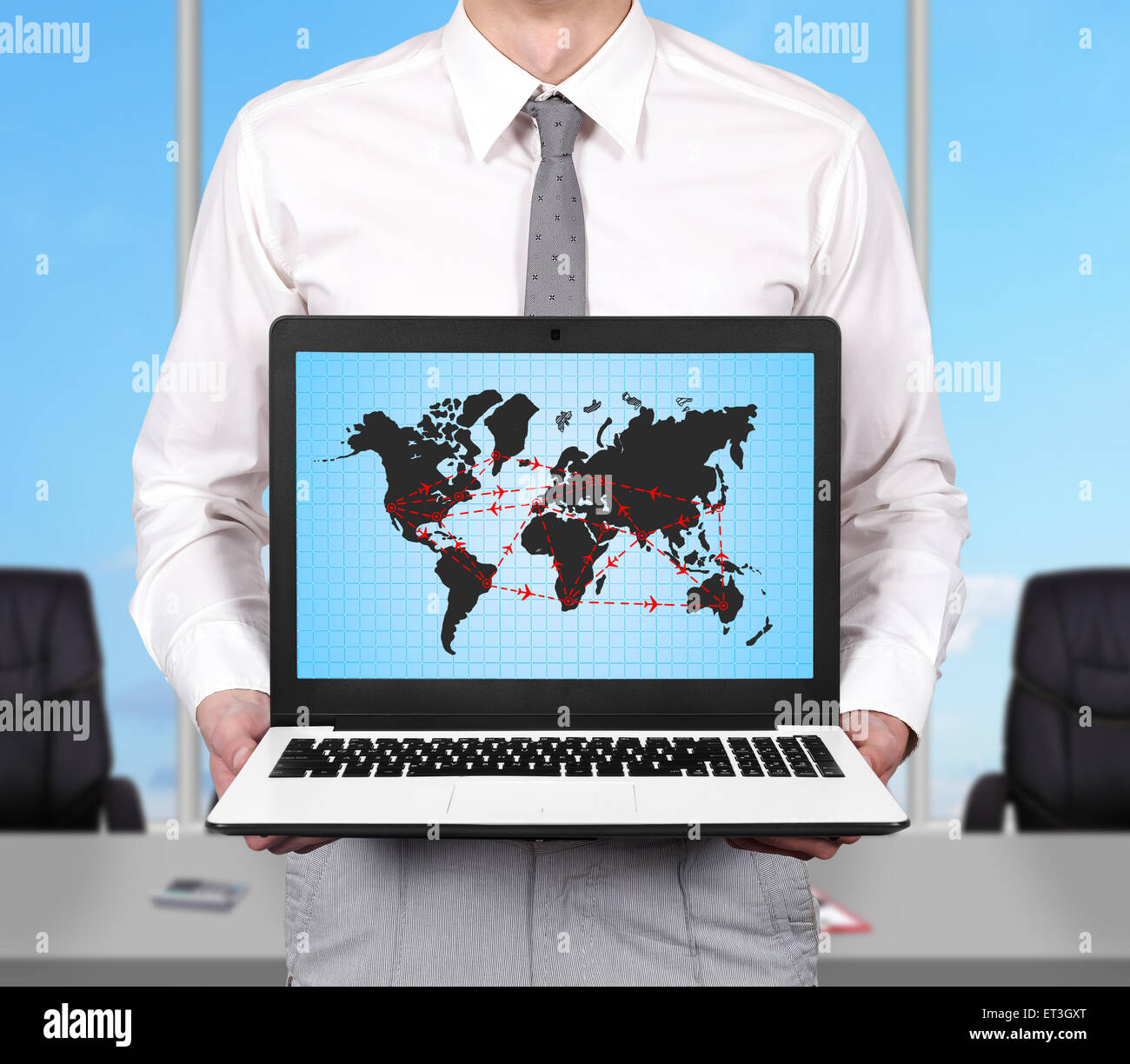 young businessman holding laptop with air travel scheme Stock Photo