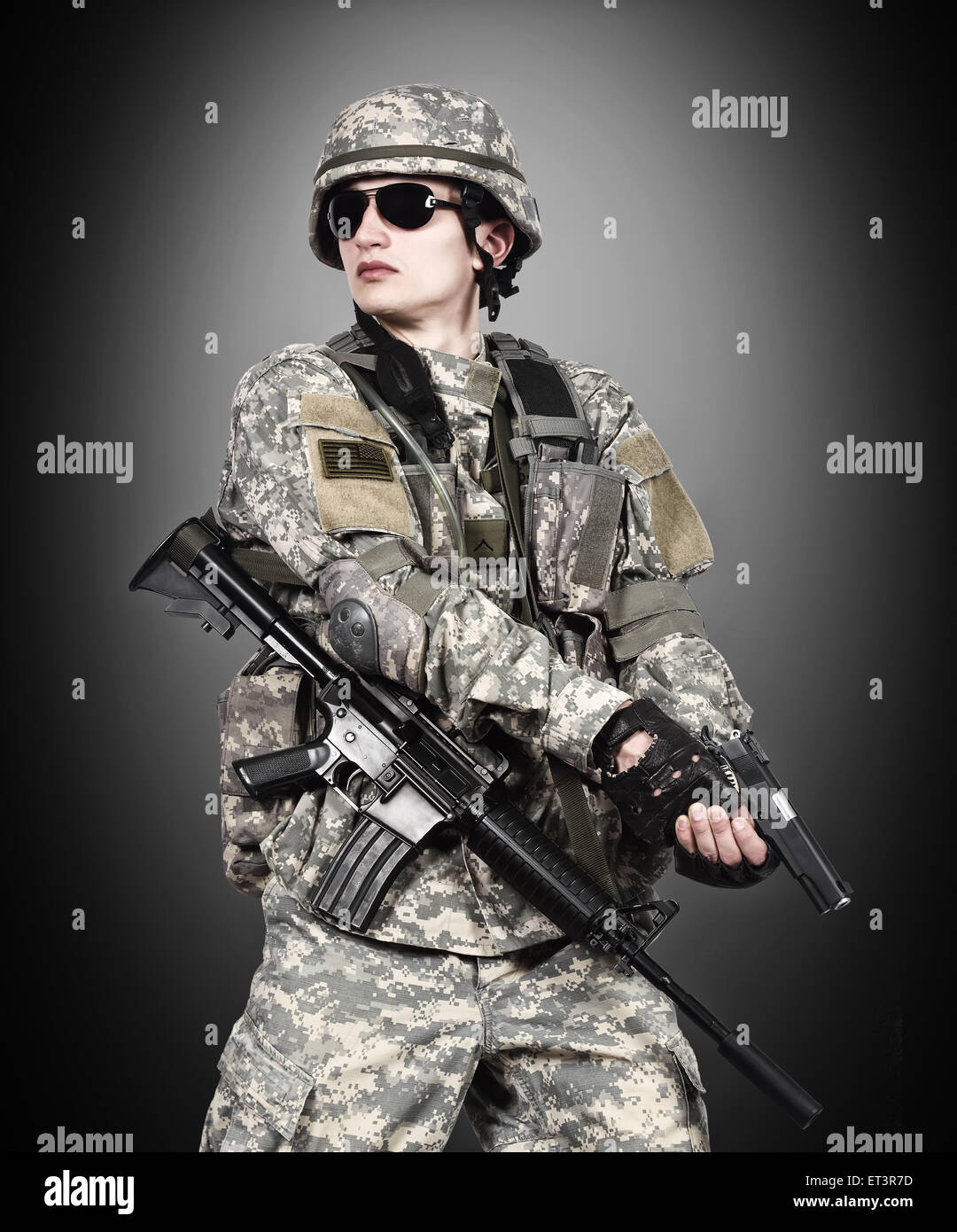US soldier holding gun on a black background Stock Photo - Alamy