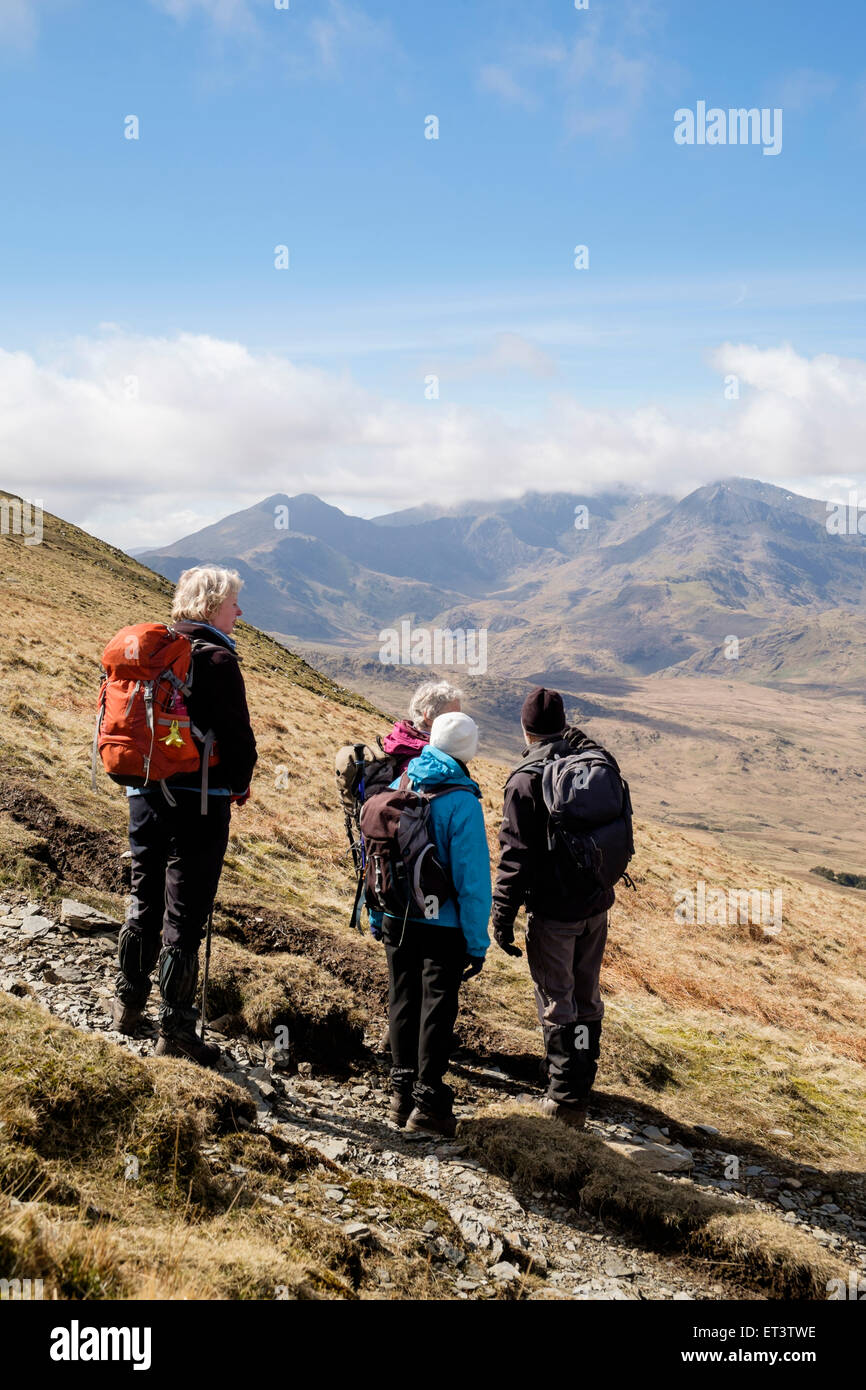 Hikers look at view to Mount Snowdon Horseshoe on path from Moel Siabod to Capel Curig in mountains of Snowdonia Wales UK. Stock Photo