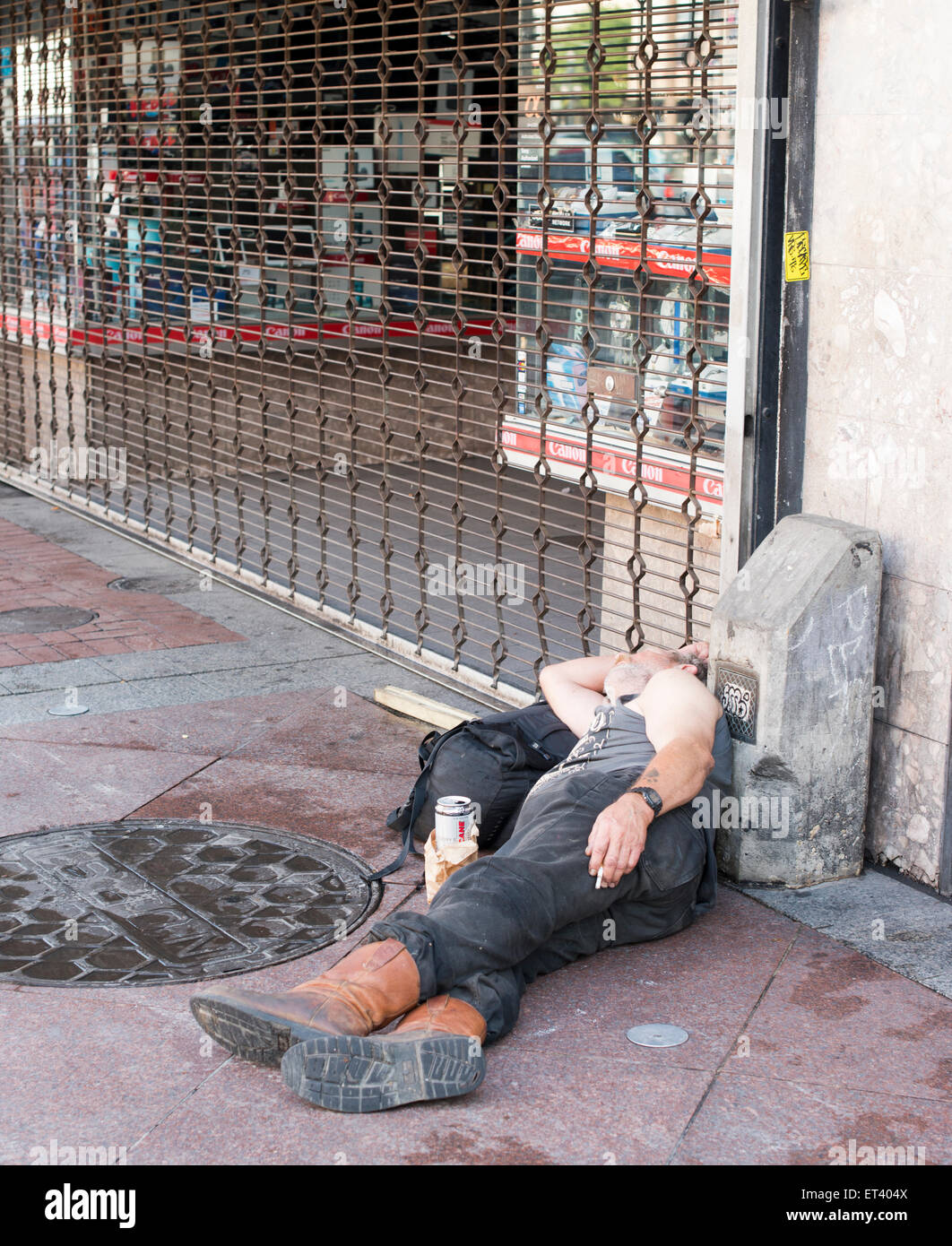 Drunk homeless man sleeping on the street near a shop in the French Quarter in New Orleans Louisiana Stock Photo