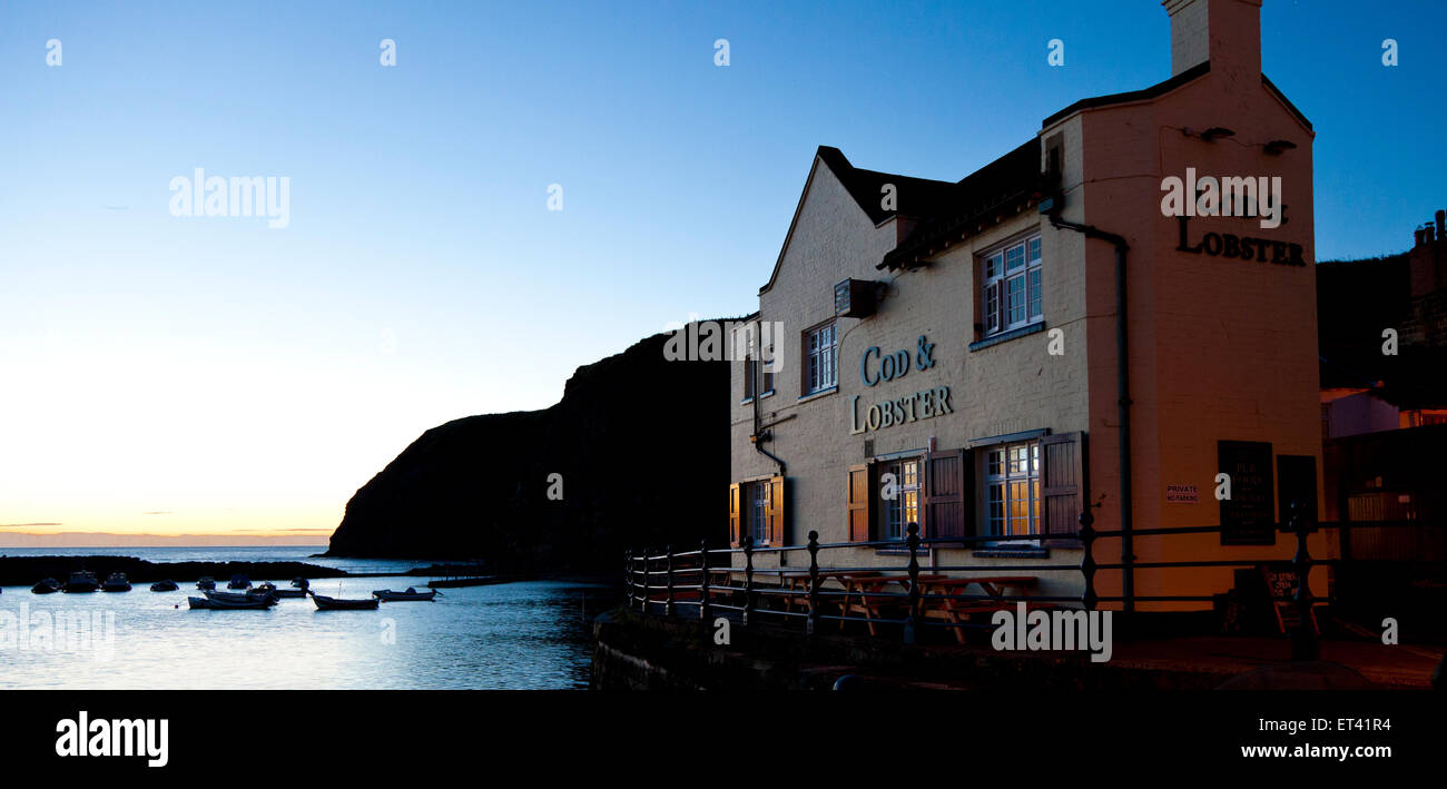 Sunrise illuminates the Cod and Lobster Pub in the village of Staithes