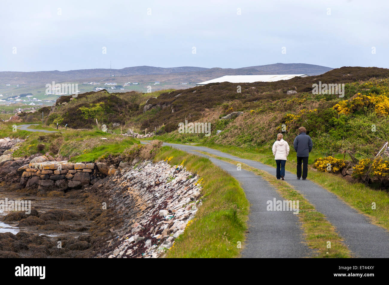 A couple walking on the Burtonport Railway Walk cycle path Donegal Ireland Stock Photo