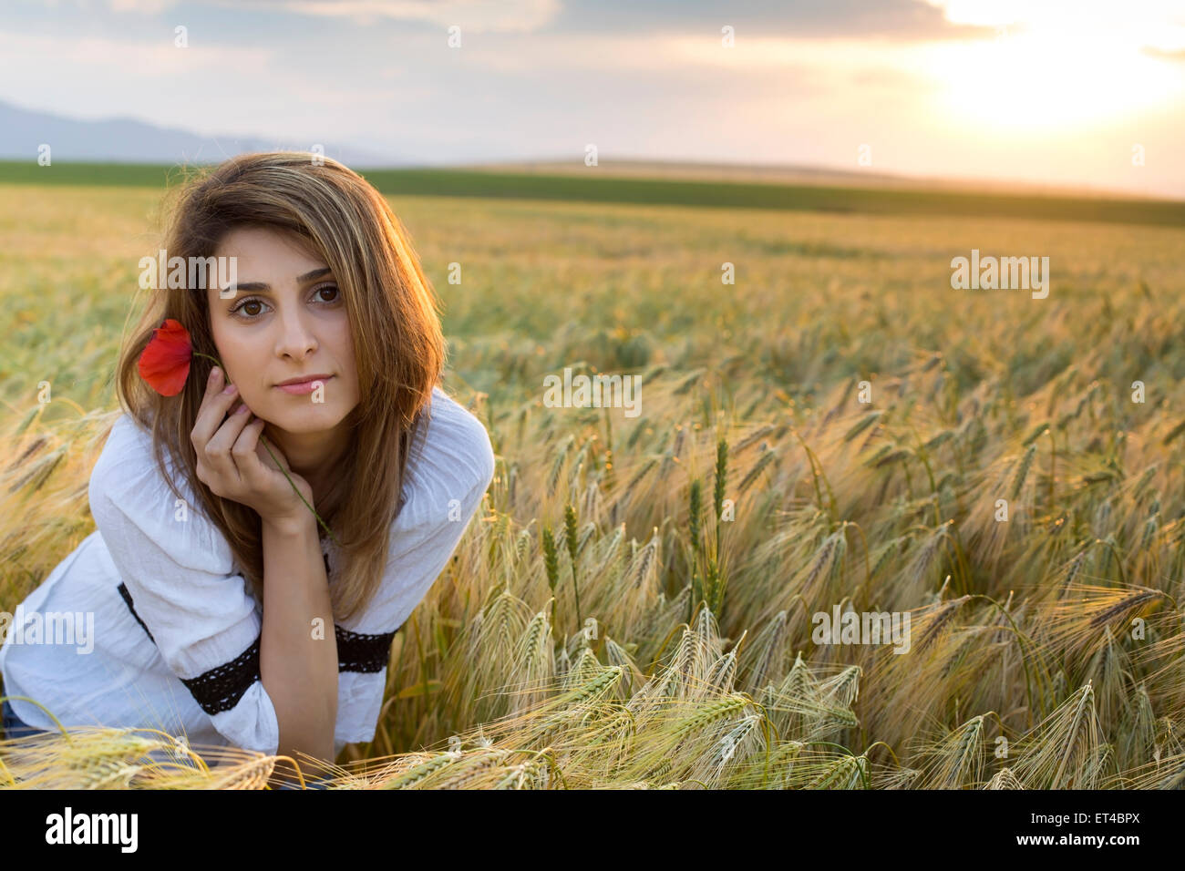 Young beautiful woman with poppy flower in wheat Field Stock Photo - Alamy