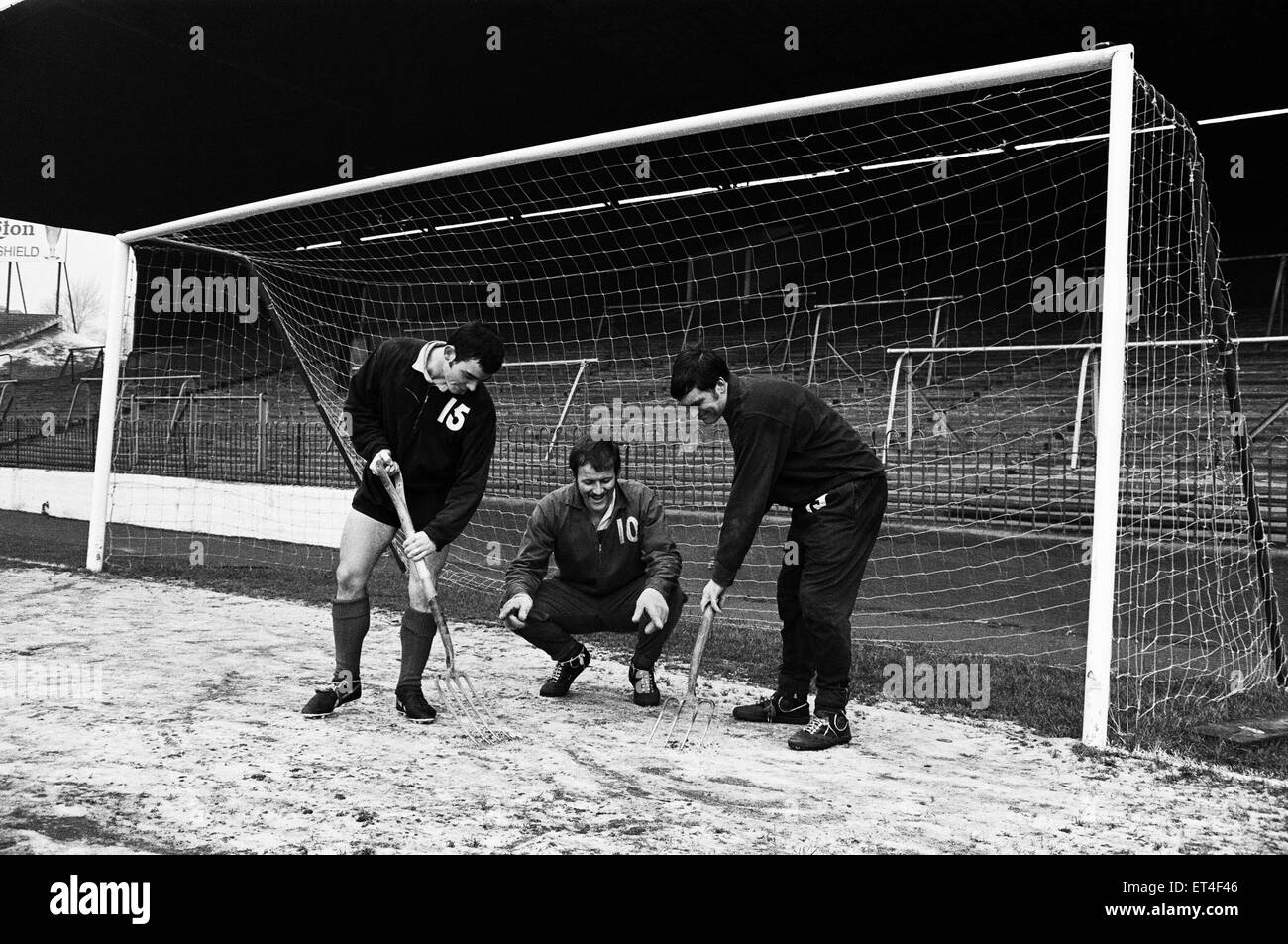 Charlton Athletic team training session at the Valley.  Goalkeeper Charlie Wright directs ice clearing operations in the goalmouth as Brian Kinsey and Keith Peacock break up the ice in preparation for the team's upcoming FA Cup third round match against local rivals Crystal Palace.  31st December 1968. Stock Photo