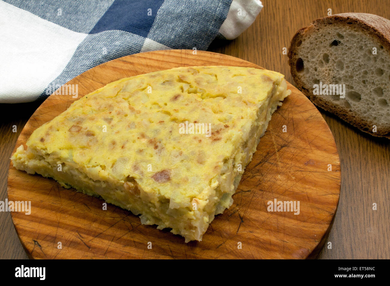 a portion of a traditional spanish omelet over a wooden board Stock Photo
