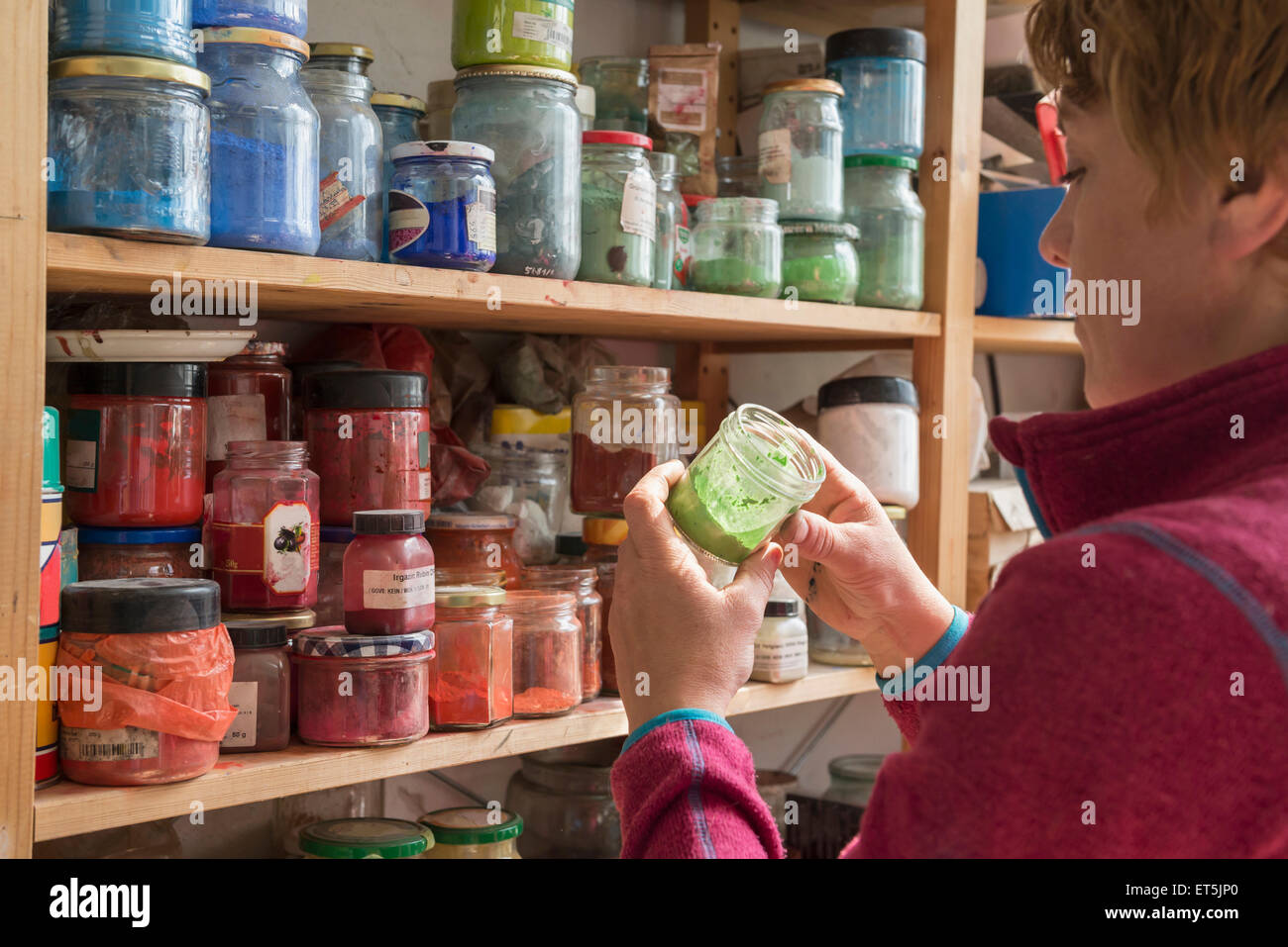 Female painter holding color bottle in art studio, Bavaria, Germany Stock Photo