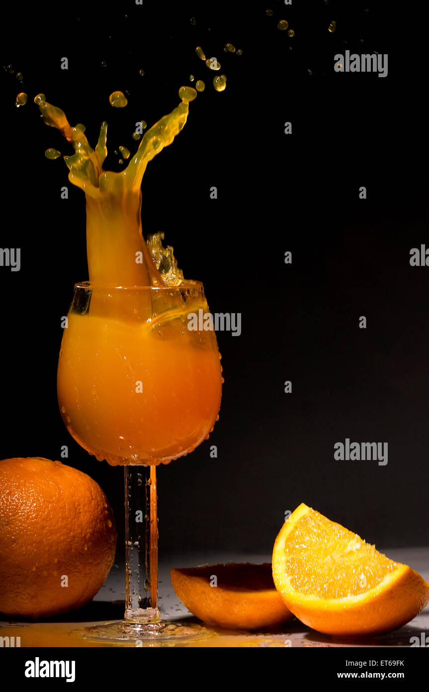 A splash of orange juice in a wine glass Stock Photo Alamy