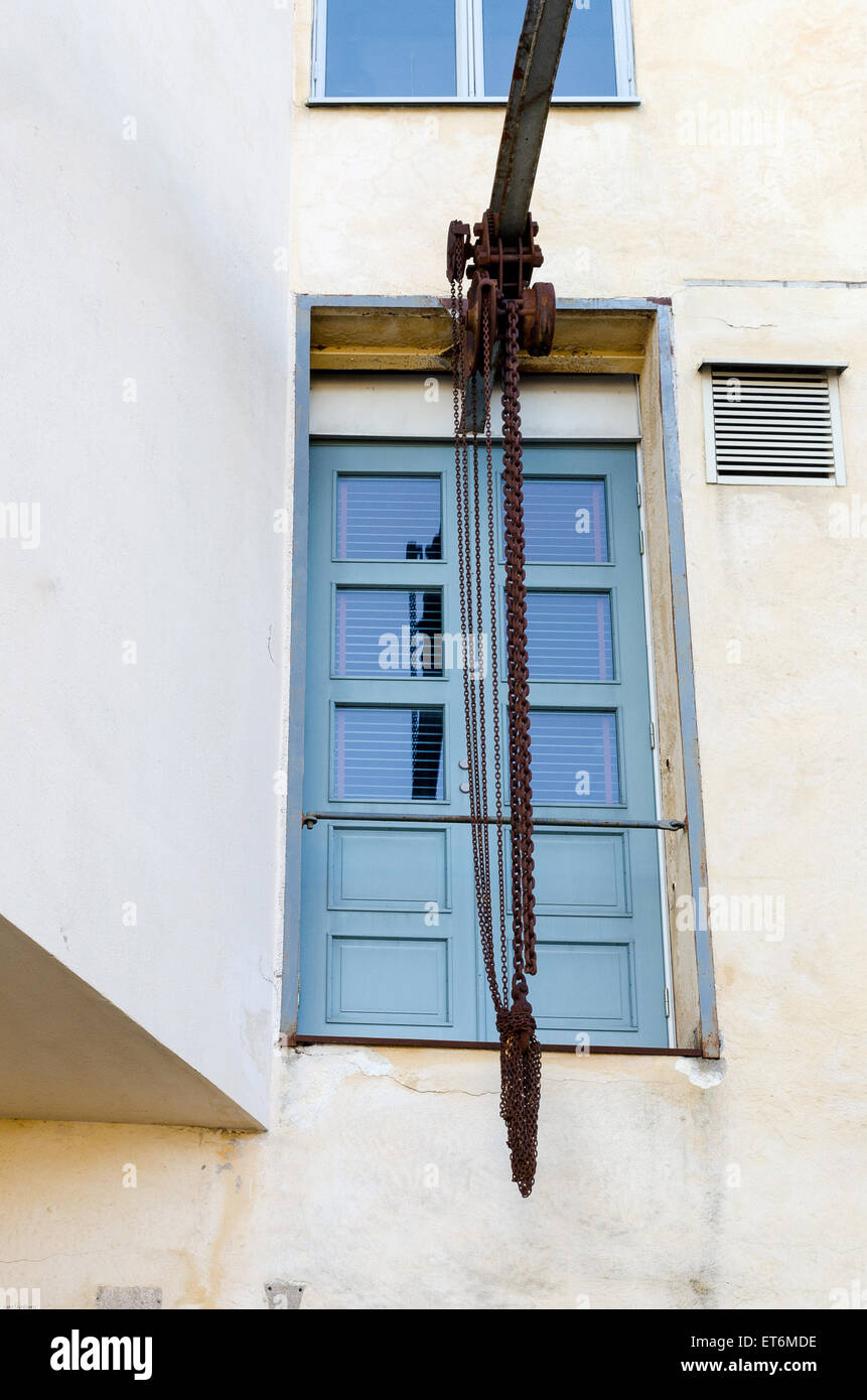 one old pulley with a rusty chain ready to lift Stock Photo