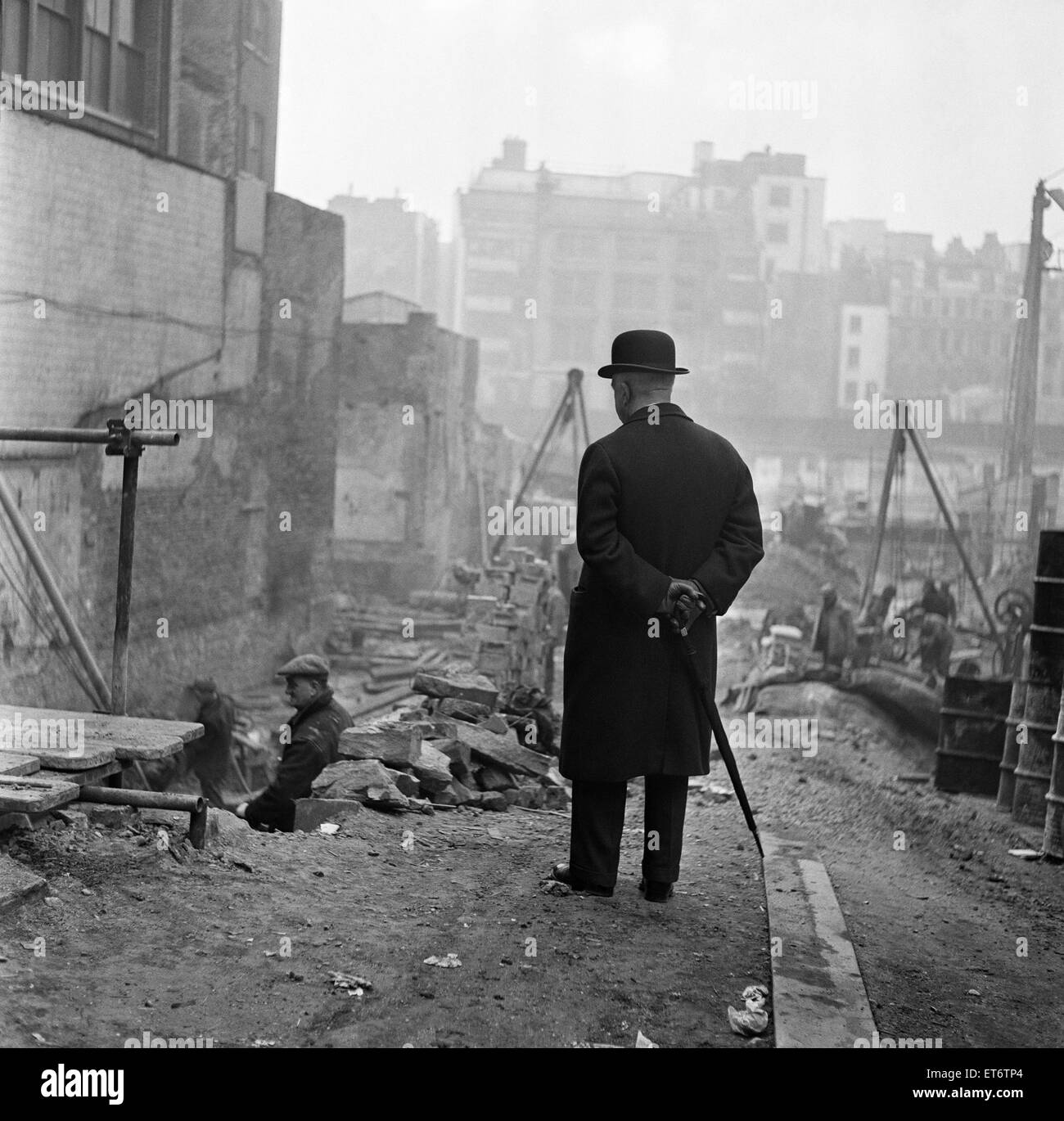 A city gent watching men working in Leadenhall Street, London. March 1954. Stock Photo