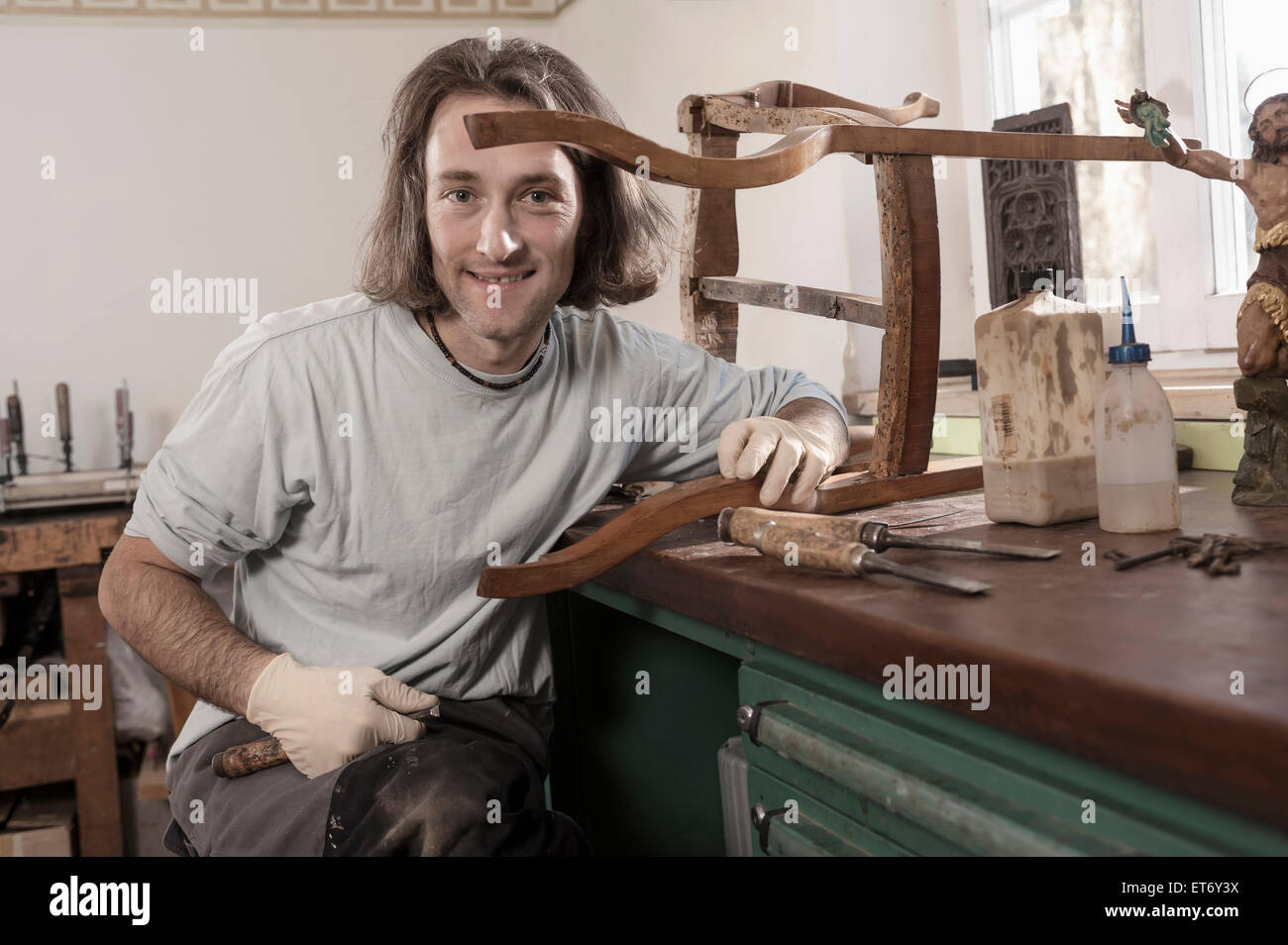 Carpenter repairing an antique wooden chair at workshop, Bavaria, Germany Stock Photo
