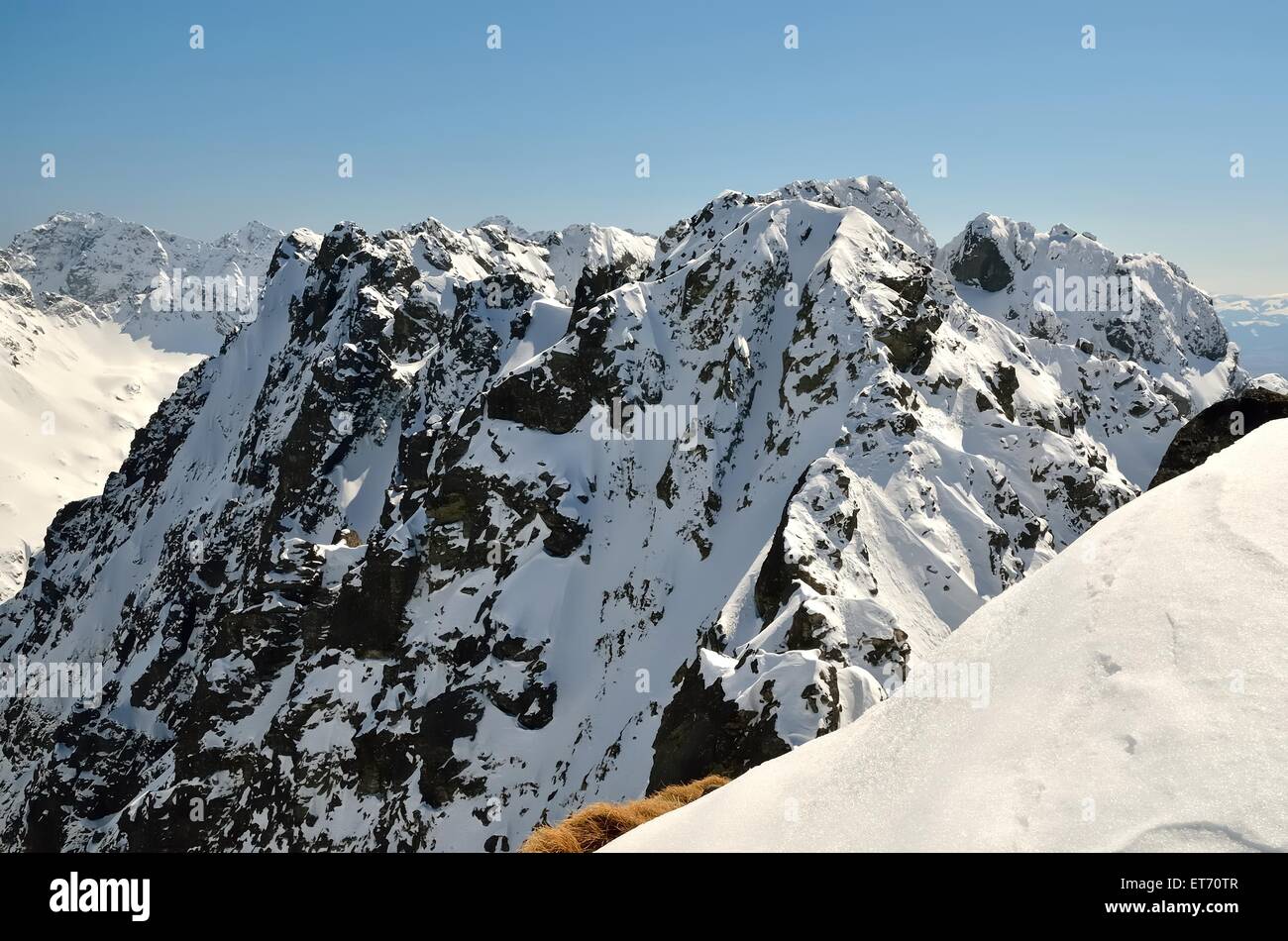 Winter landscape in mountains. View from the ridge over steep slopes and snowy peaks, National Park in Tatra Mountains. Stock Photo