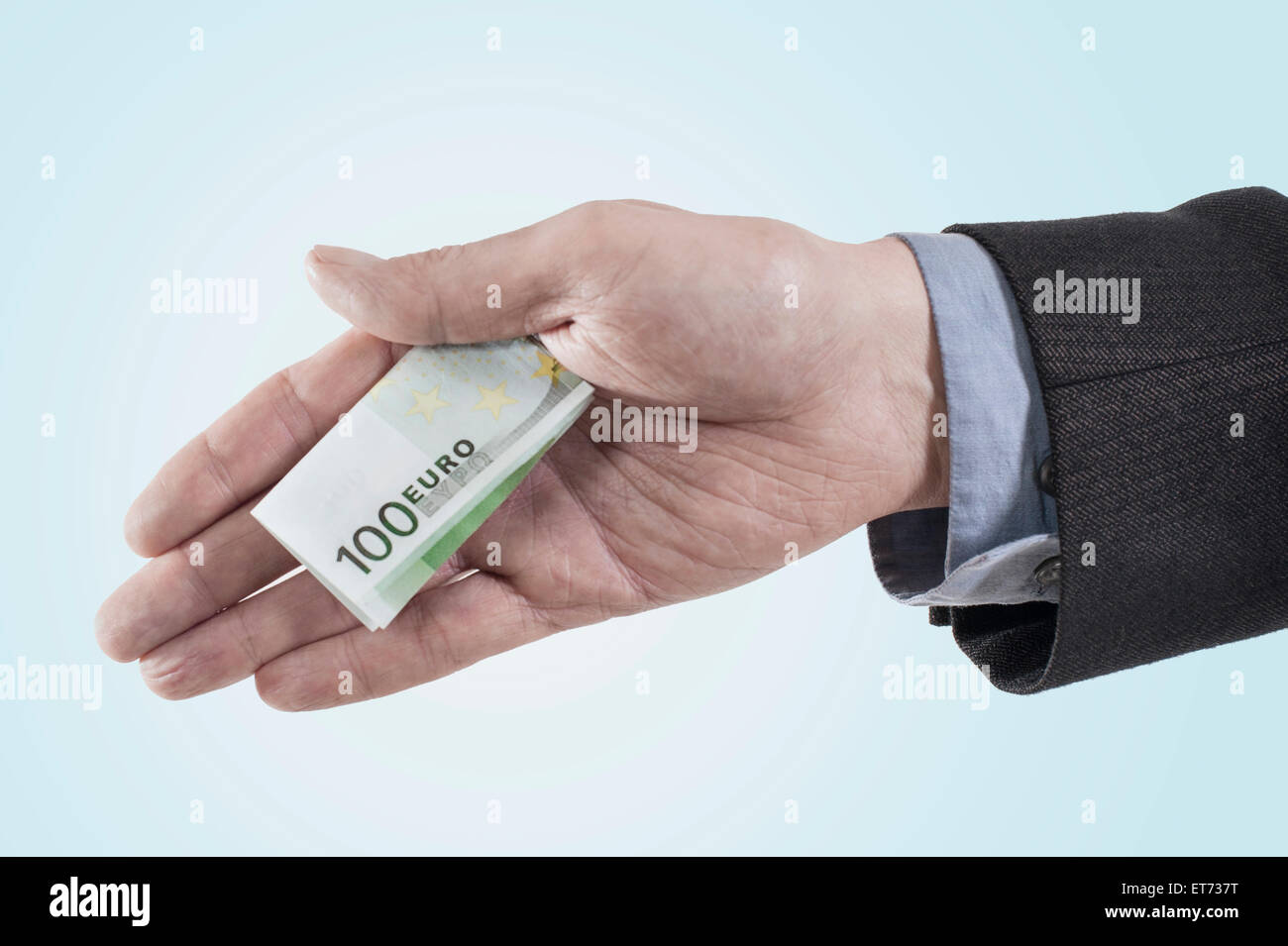 Businessman holding out bribing cash, Bavaria, Germany Stock Photo