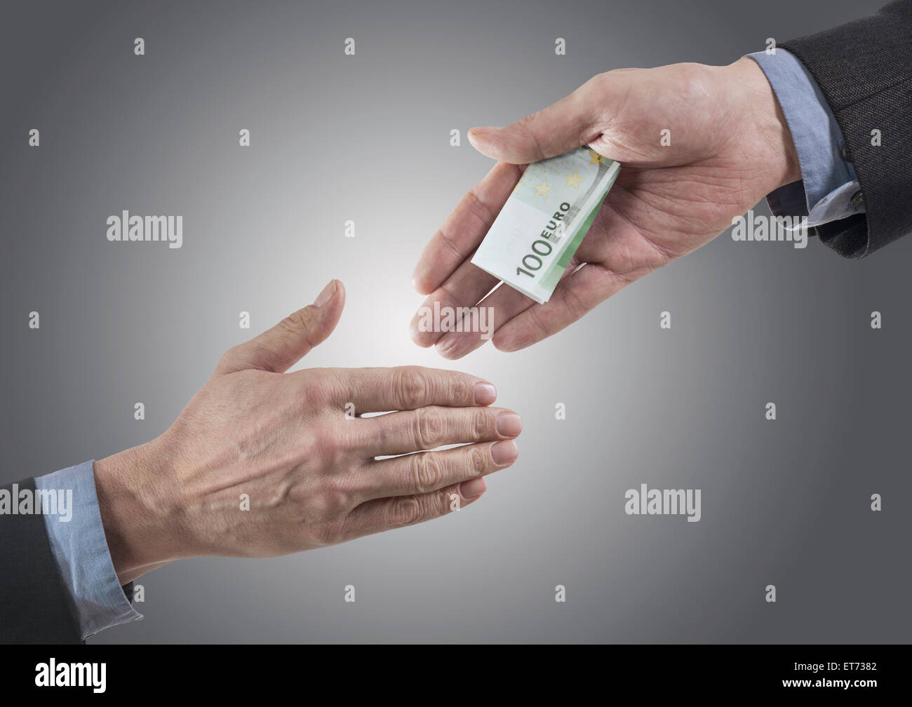 Businessman holding out bribing cash with handshake, Bavaria, Germany Stock Photo