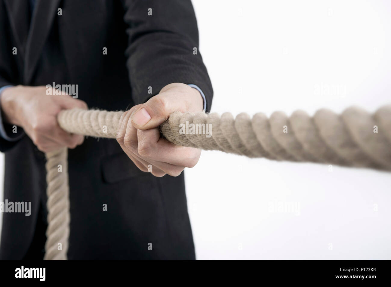 Mid section view of businessman pulling rope, Bavaria, Germany Stock Photo