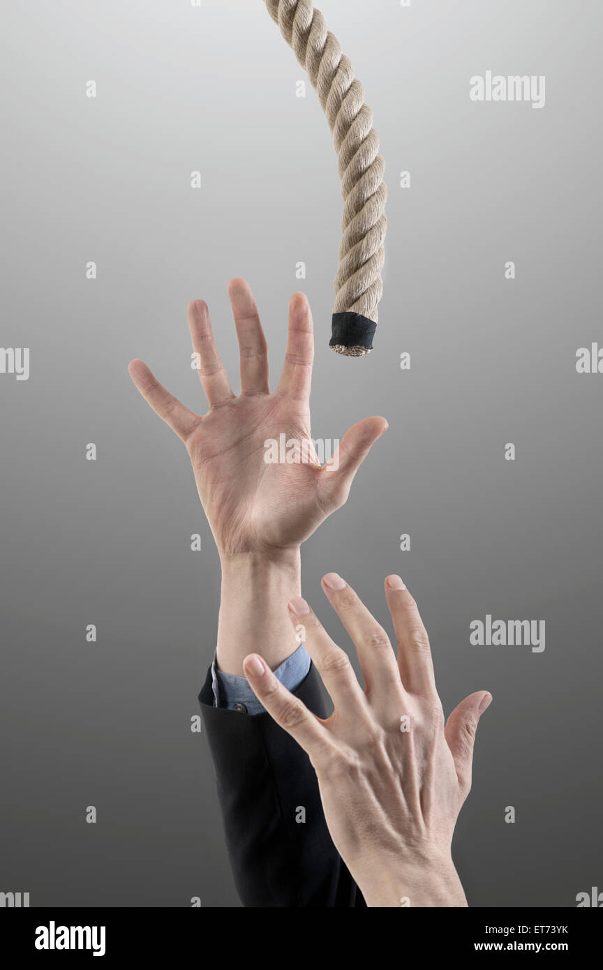 businessman's hands reaching for a rope for salvation, Bavaria, Germany Stock Photo