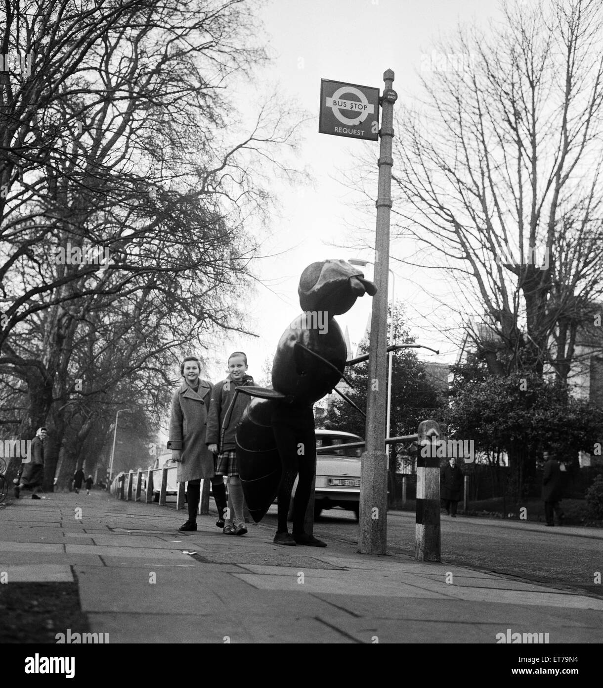 A 'Zarbi', from the Dr Who television serial (written by Bill Struttonwill) ,'The Web Planet'.  The Zarbi stands at a bus stop outside the BBC TV studio at Ealing, West London, with two local children. The Zarbi (designed by John Wood), has an ant like ap Stock Photo