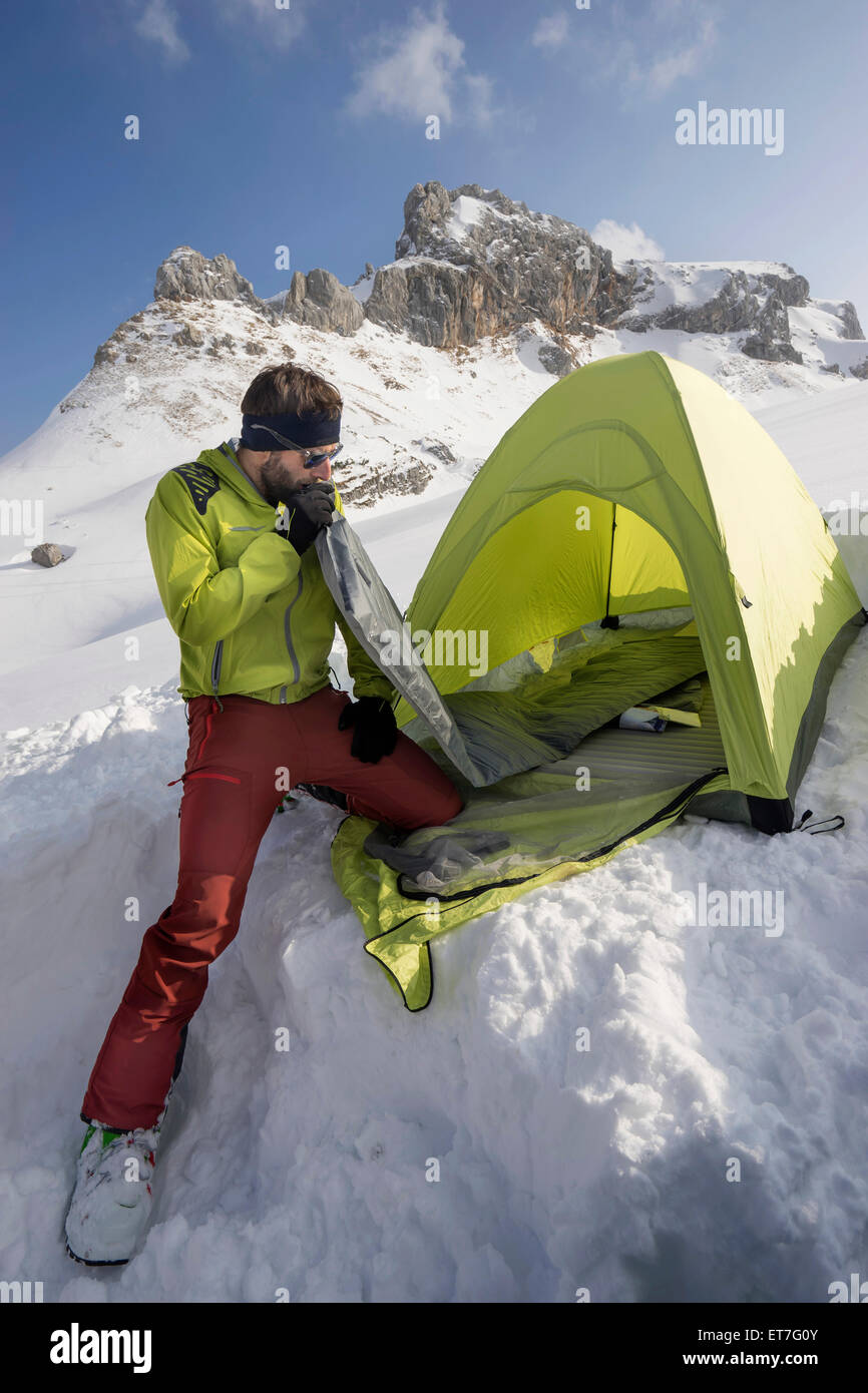 Man blowing into air mattress for camping, Tyrol, Austria Stock Photo