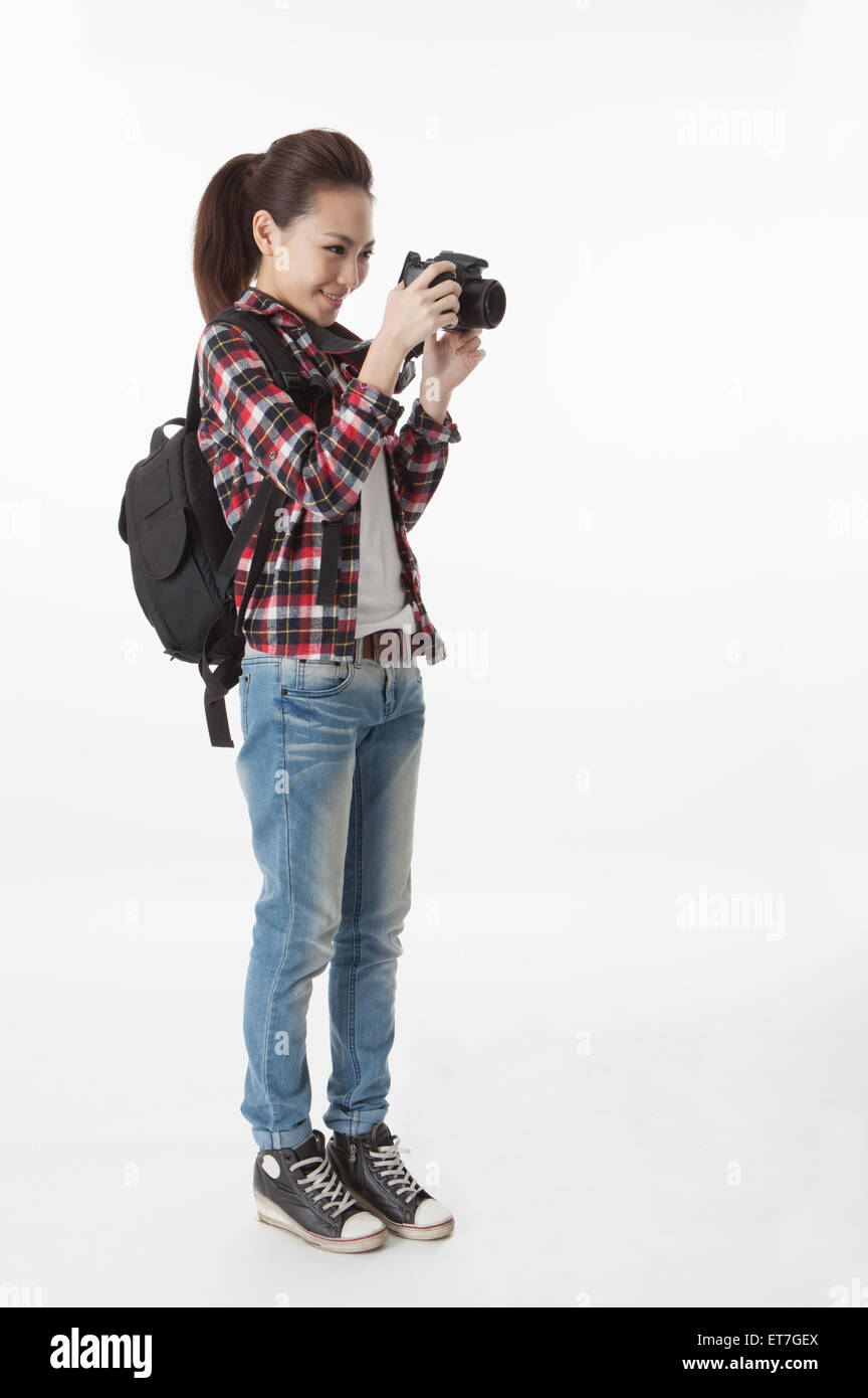 Young woman standing and holding camera with smile Stock Photo - Alamy