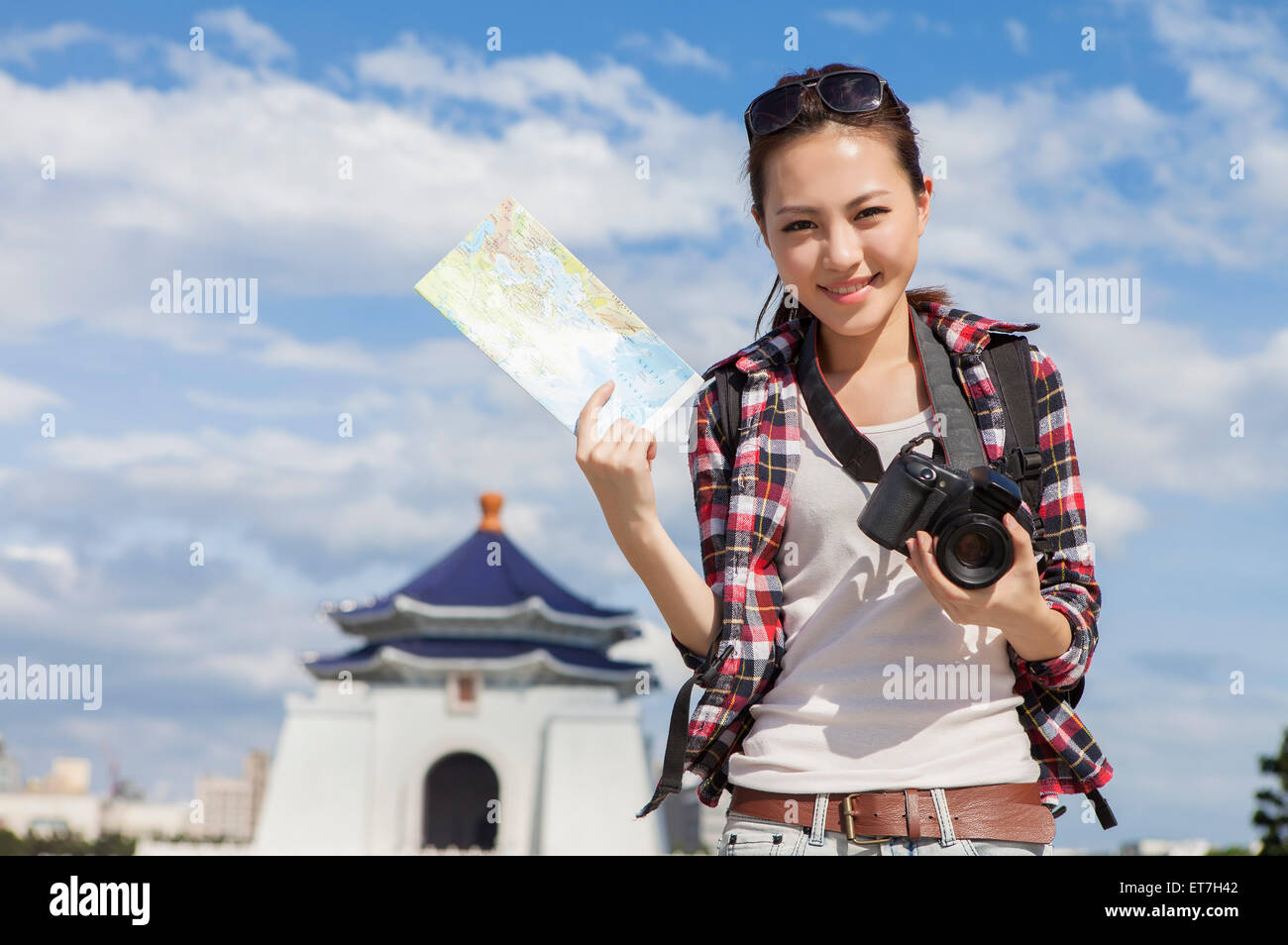 Young woman holding camera and map with smile Stock Photo - Alamy