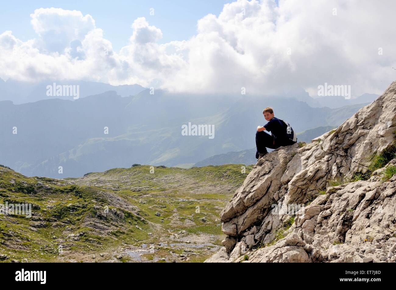 zehnjaehriger Junge beim Bergwandern macht eine Verschnaufpause, Deutschland, Bayern, Allgaeu | ten years old boy at mountain hi Stock Photo