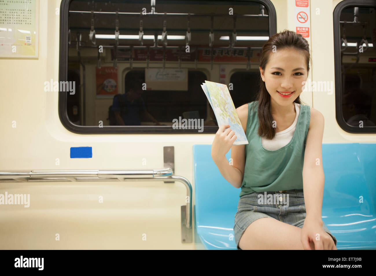 Young woman holding a map and smiling at the camera Stock Photo - Alamy