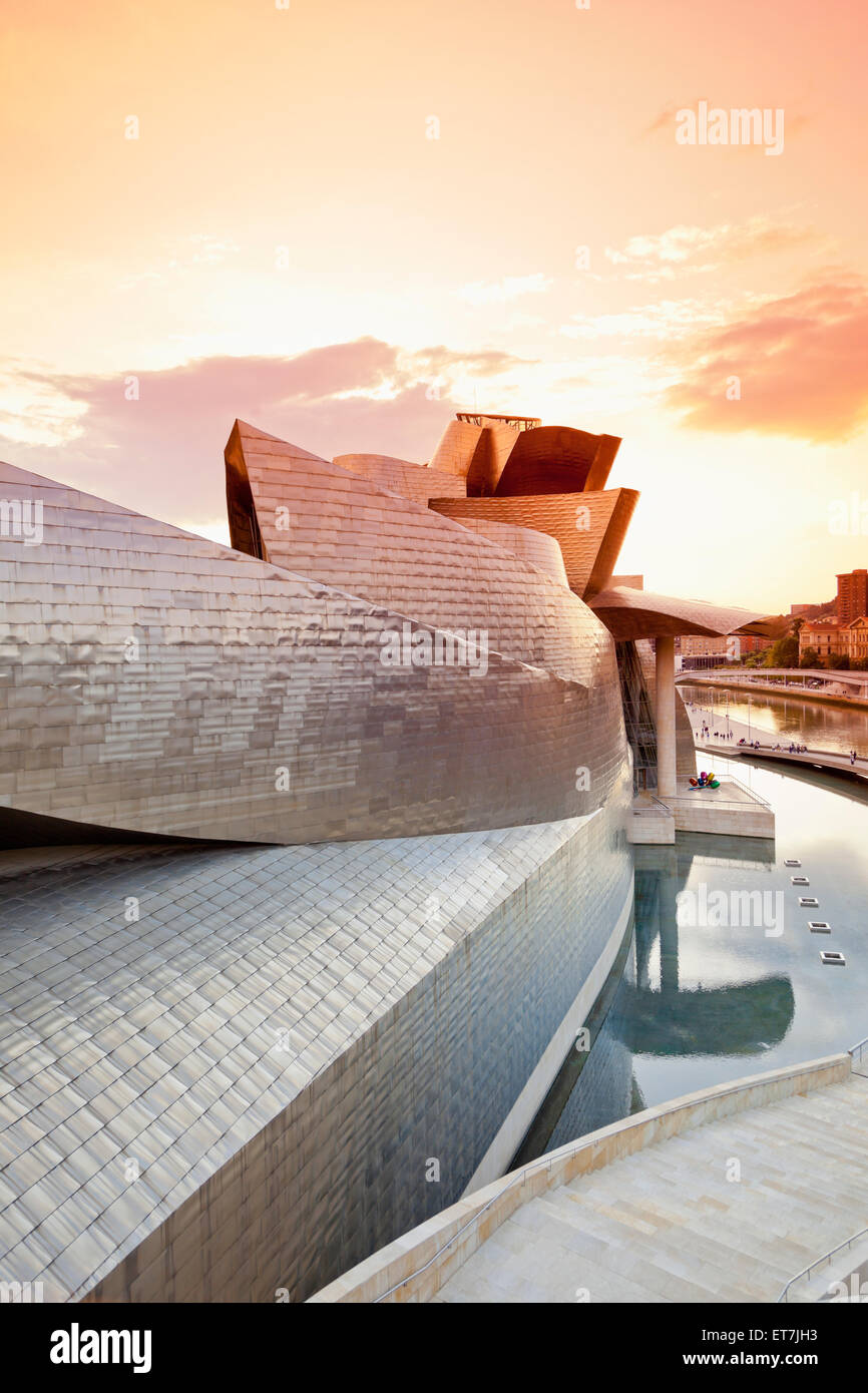 Spain, Basque Country, Bilbao, Guggenheim Museum by Frank Owen Gehry in the evening Stock Photo