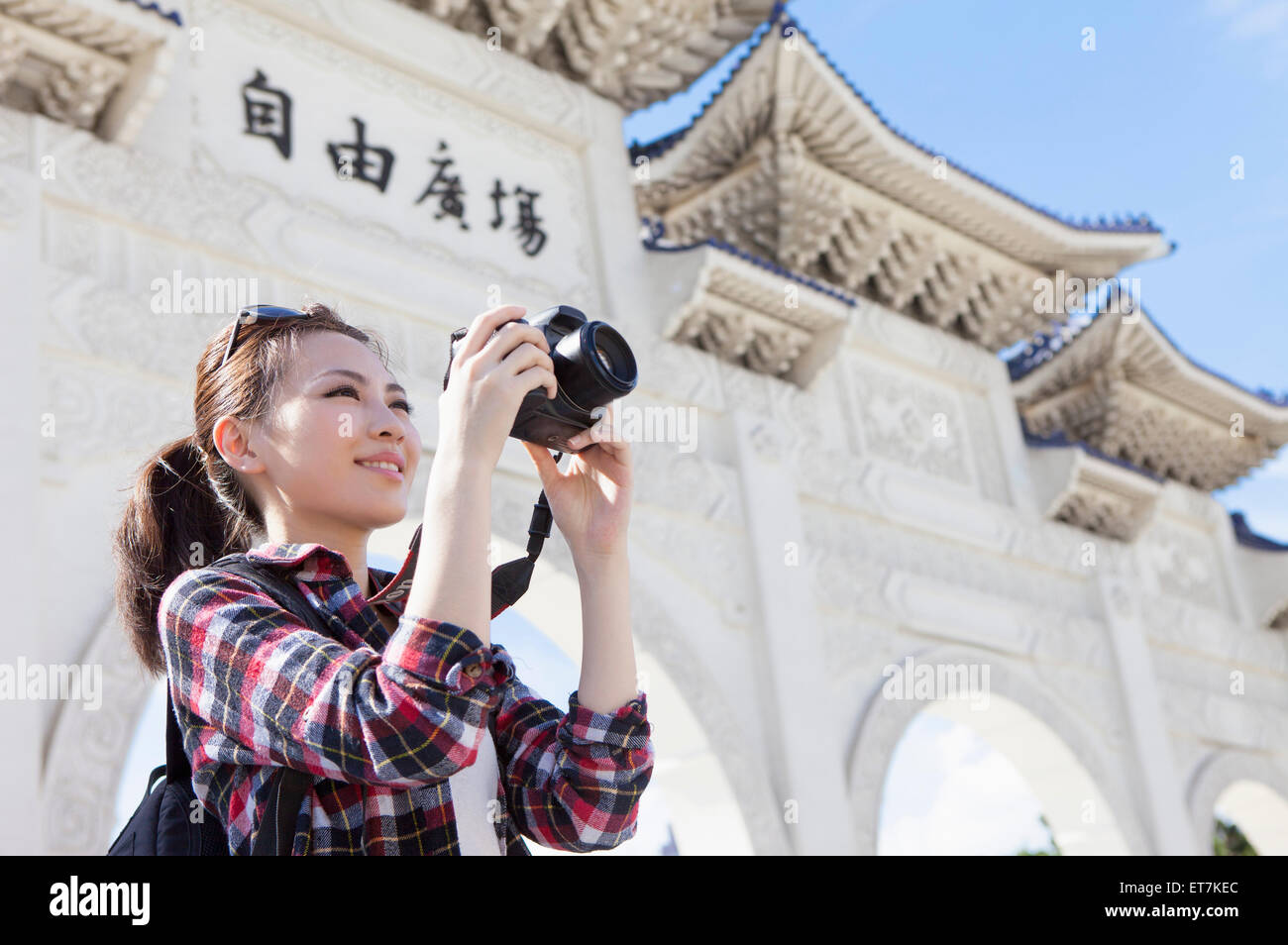 Young woman holding camera and photographing Stock Photo - Alamy