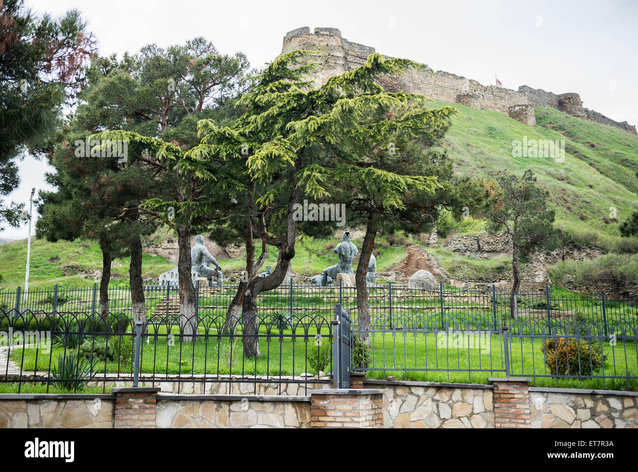 Monument in front of hill with medieval citadel called Gori Fortress in Gori town, Goergia Stock Photo