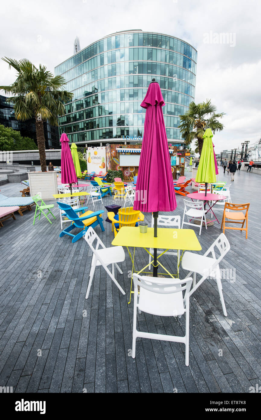 London Riviera Pop Up Restaurant next to City Hall in London with colourful deck chairs and fake crocodile table with city views Stock Photo