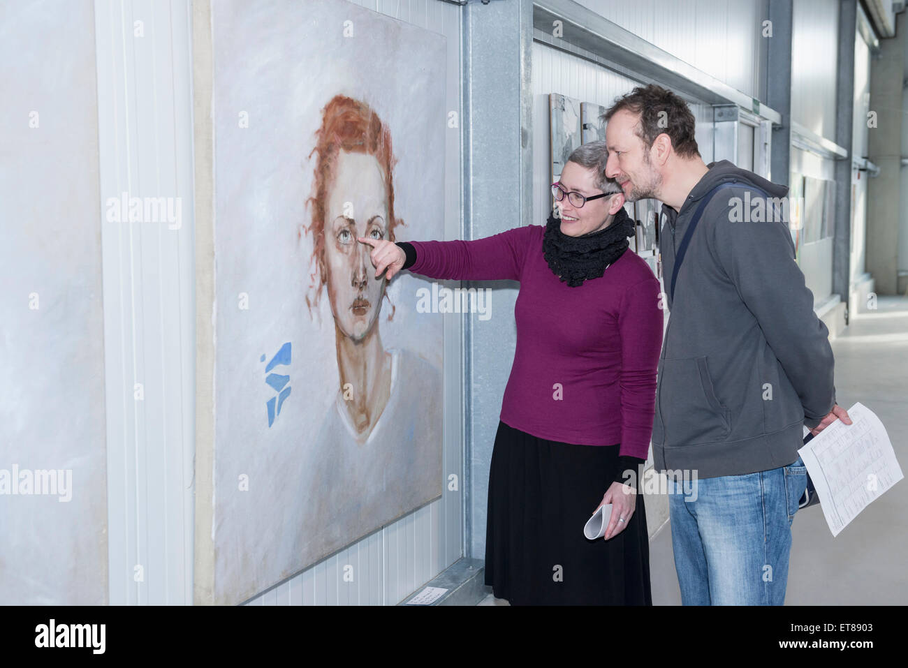 Visitors looking at paintings in an art gallery, Bavaria, Germany Stock