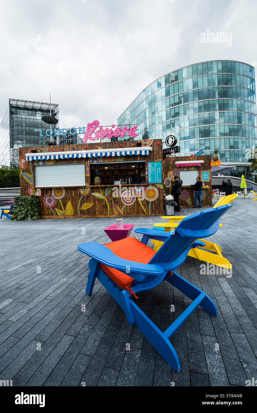 London Riviera Pop Up Restaurant next to City Hall in London with colourful deck chairs and fake crocodile table with city views Stock Photo