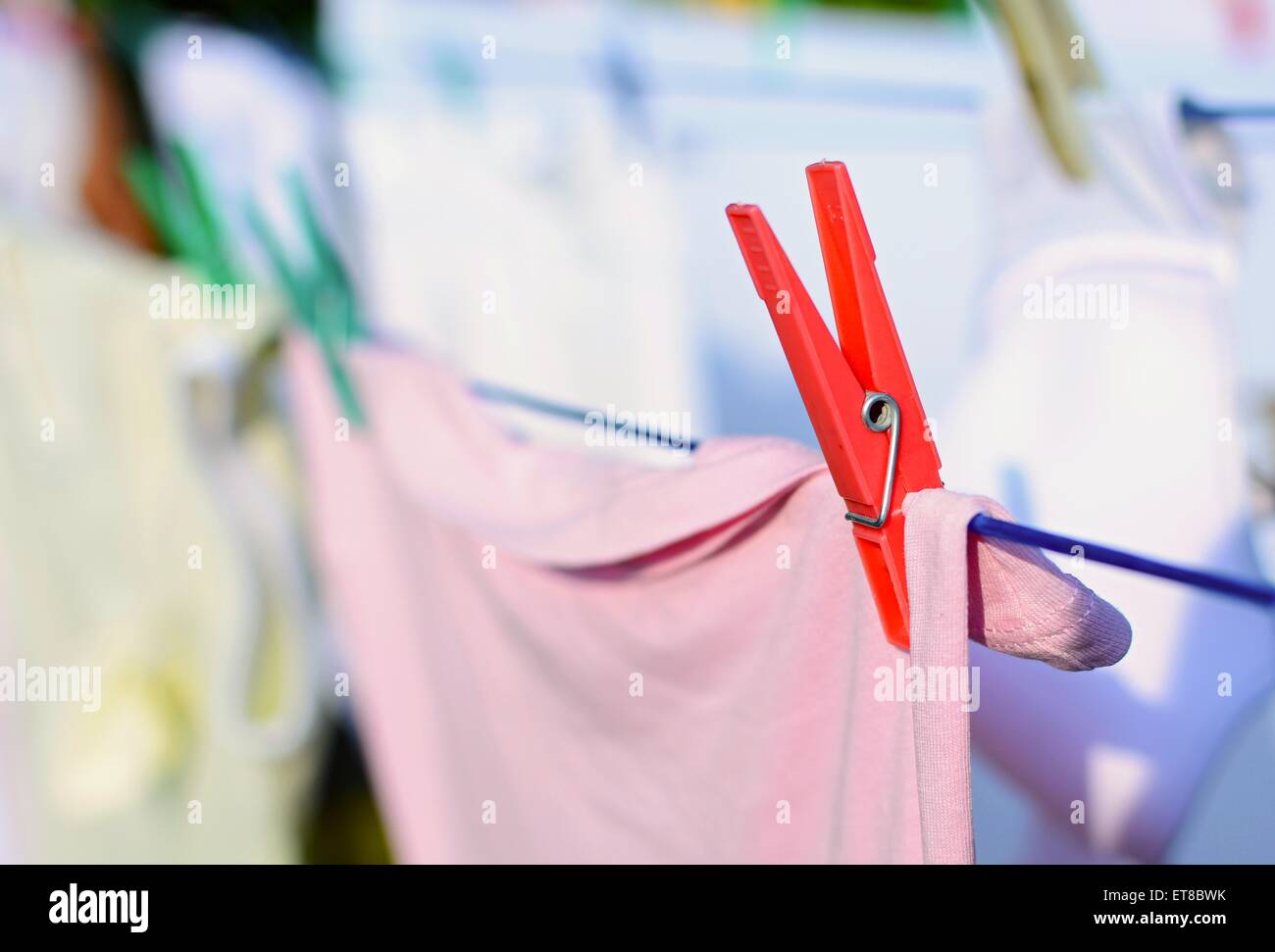 Closeup of the red peg with fresh laundry on the clothesline. Stock Photo