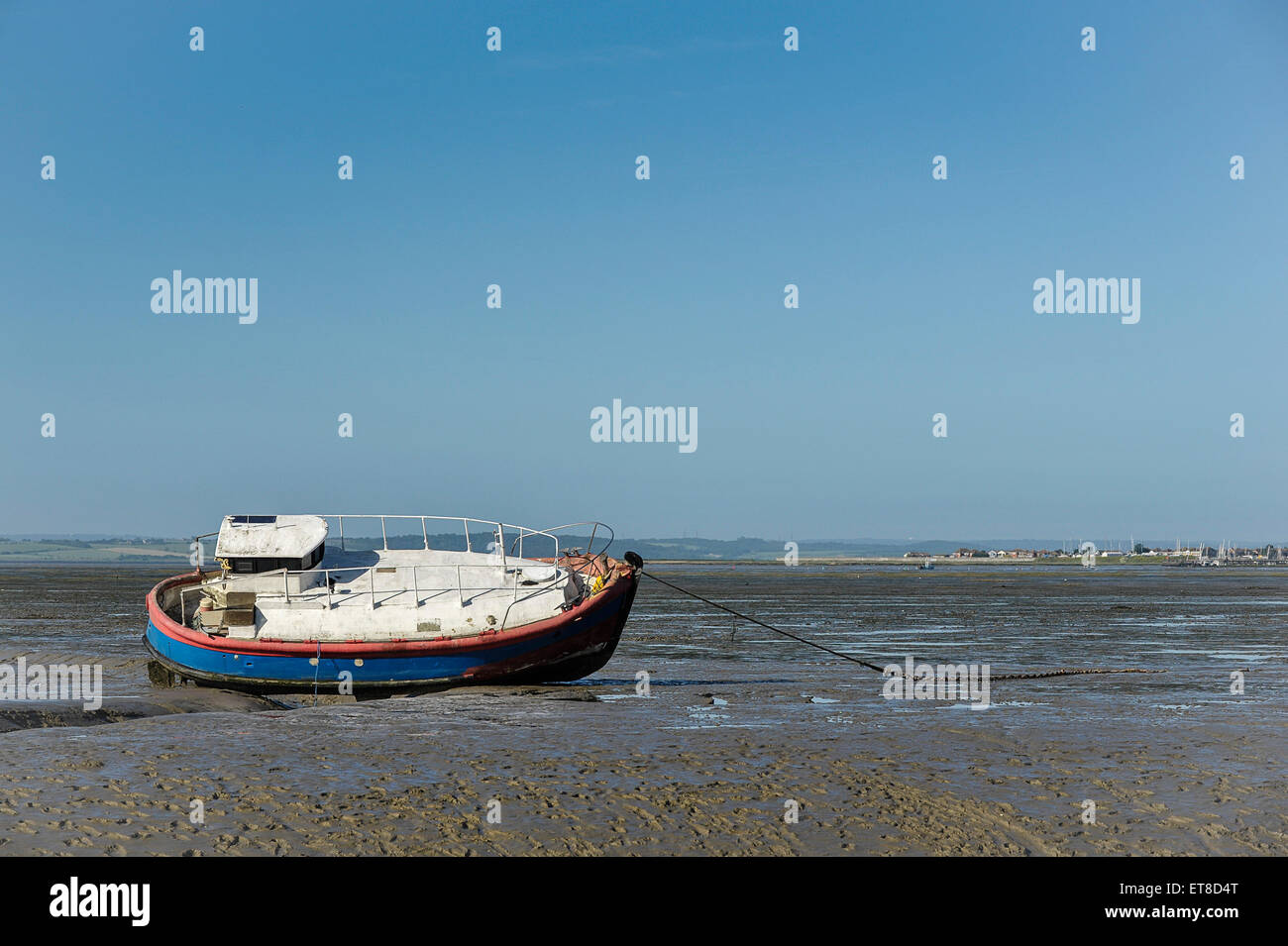 A boat moored on the Thames Estuary mudflats at low tide. Stock Photo