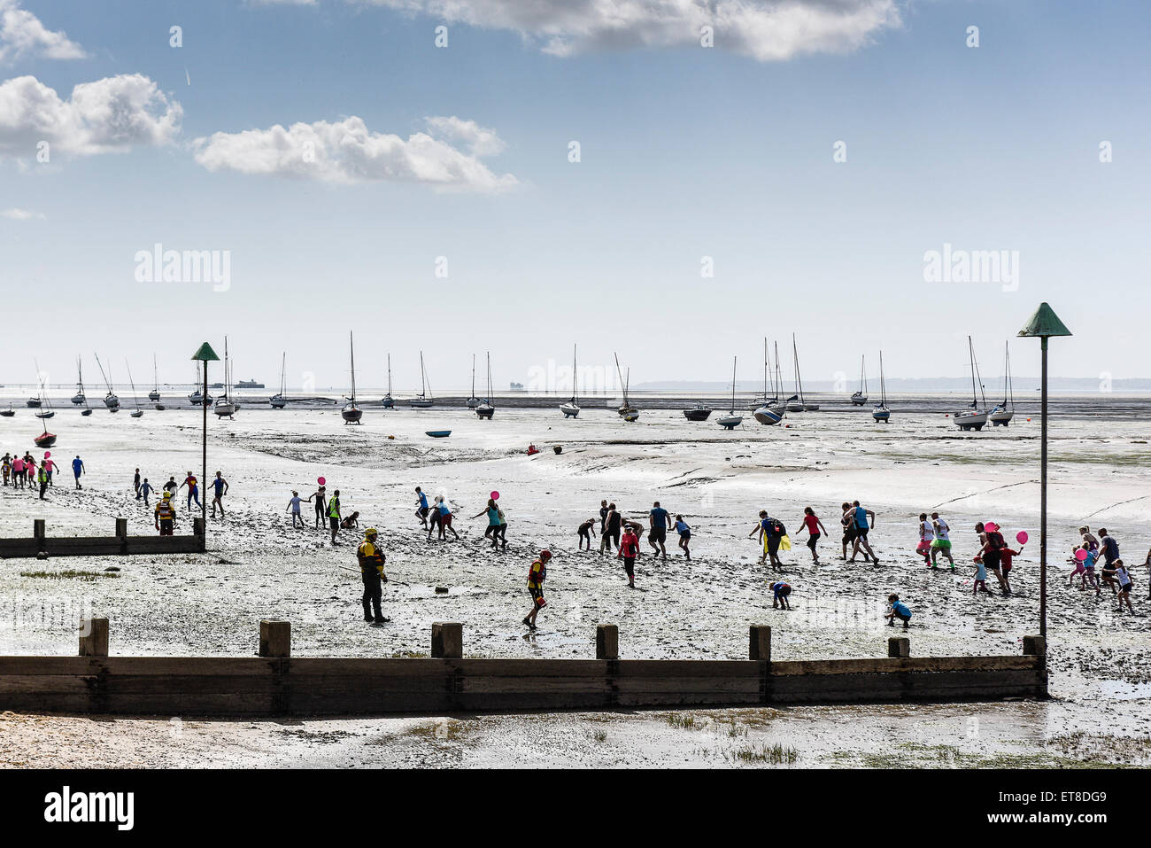 The annual charity fun run across the muddy Thames Estuary foreshore at Leigh on Sea, Essex. Stock Photo