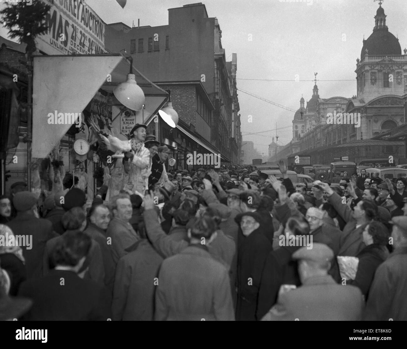 Shoppers looking for a last minute bargain gather around the poulterers stalls in Charterhouse Street close to Smithfield Market as the turkey auctions begin on Christmas Eve. Circa December 24th 1953 Stock Photo