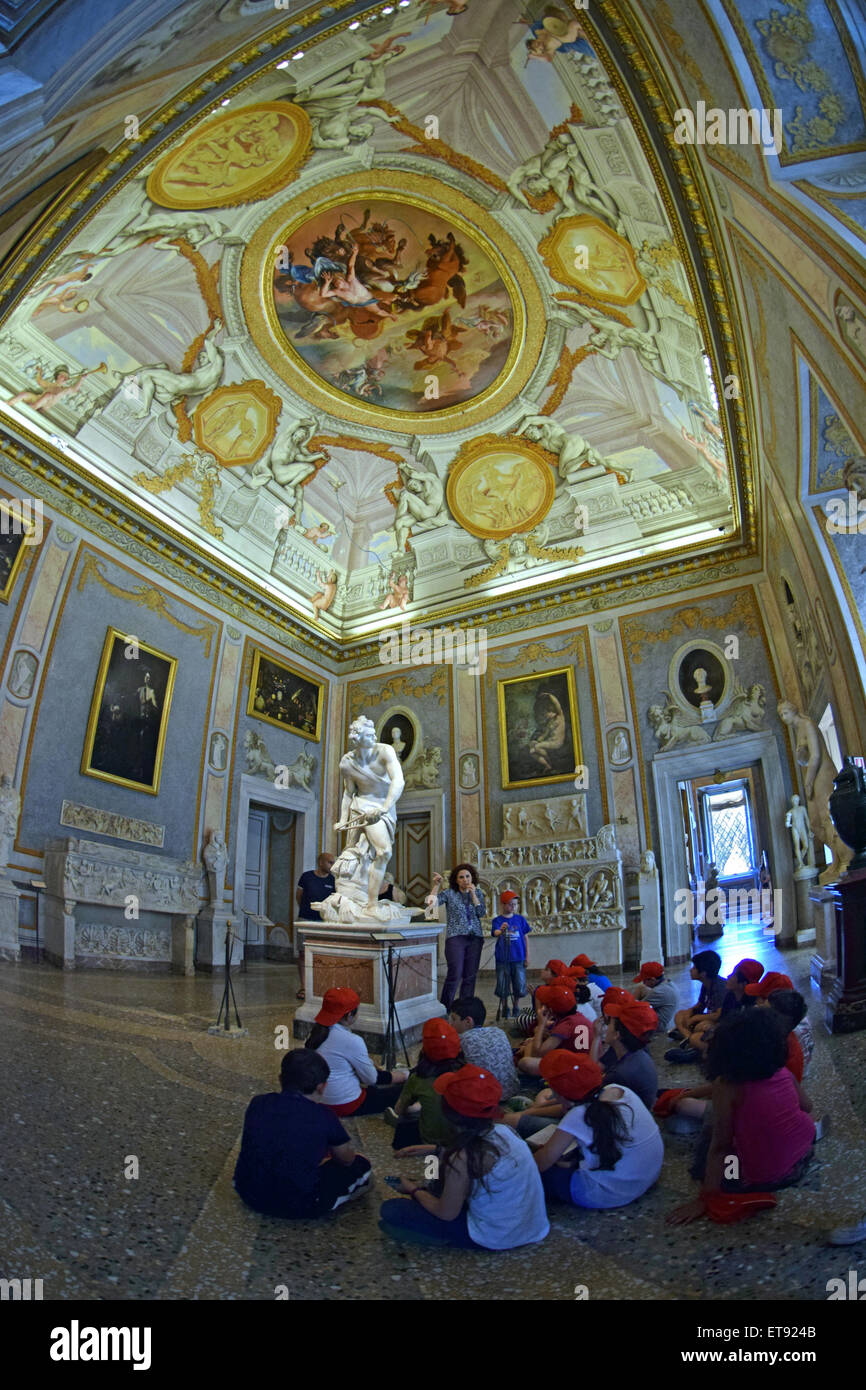 A teacher lecturing her class about the Bernini sculpture of David at the Borghese Gallery in Rome Italy Stock Photo